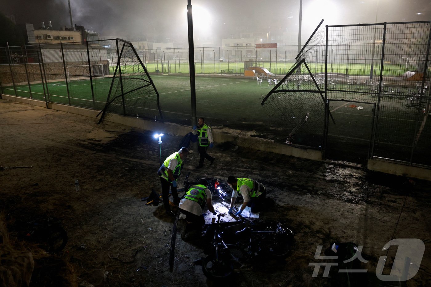 본문 이미지 - 28일(현지시간) 이스라엘 점령지 골란고원 마즈달 샴스의 한 축구장에 로켓이 떨어져 12명이 사망하고 44명이 다쳤다. 사진은 공격받은 축구장에 출동한 구조대원들의 모습. 2024.07.28/ ⓒ 로이터=뉴스1 ⓒ News1 박재하 기자