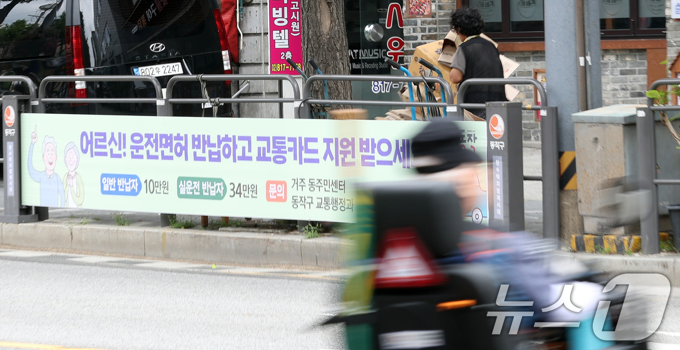 (서울=뉴스1) 김명섭 기자 = 3일 서울시 동작구 도로변에 '어르신 운전면허 반납하고 교통카드 지원 받으세요'라는 현수막이 걸려 있다.시청역 교통사고로 고령운전자에 대한 논란이 …