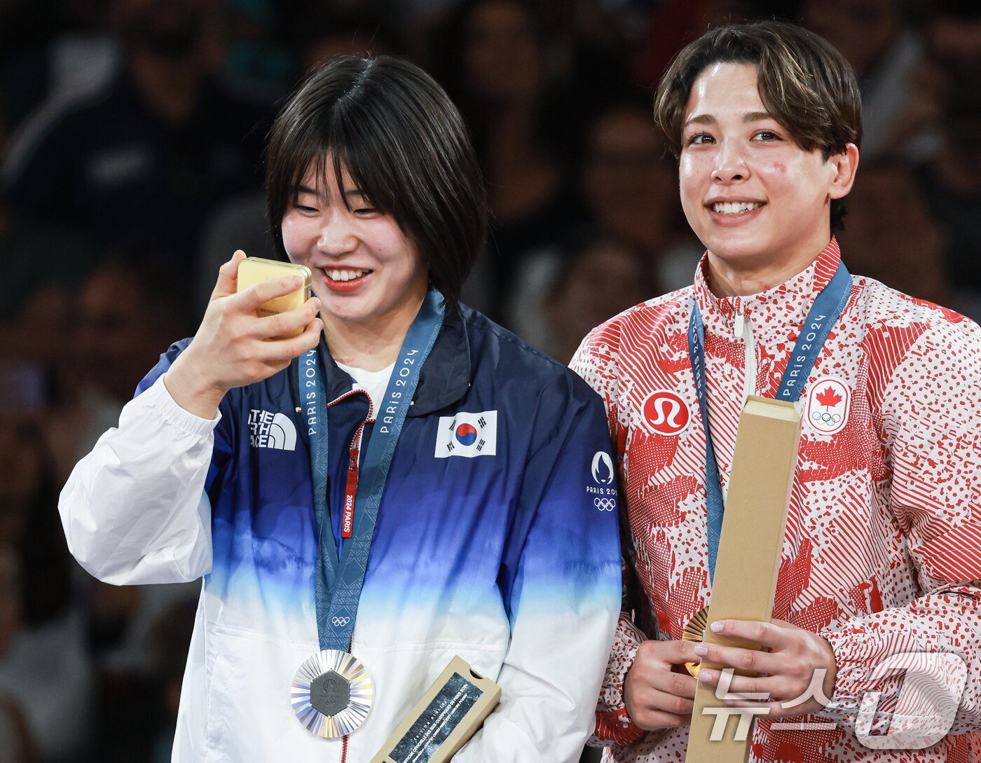 본문 이미지 - 대한민국 유도대표팀 허미미 선수가 30일&#40;한국시간&#41; 프랑스 파리 샹 드 마르스 아레나에서 열린 2024 파리올림픽 유도 여자 -57kg 시상식에서 은메달을 수여 받은 후 기념촬영을 하기 위해 건네 받은 갤럭시 Z플립6를 살펴보고 있다. 2024.7.30/뉴스1 ⓒ News1 박정호 기자