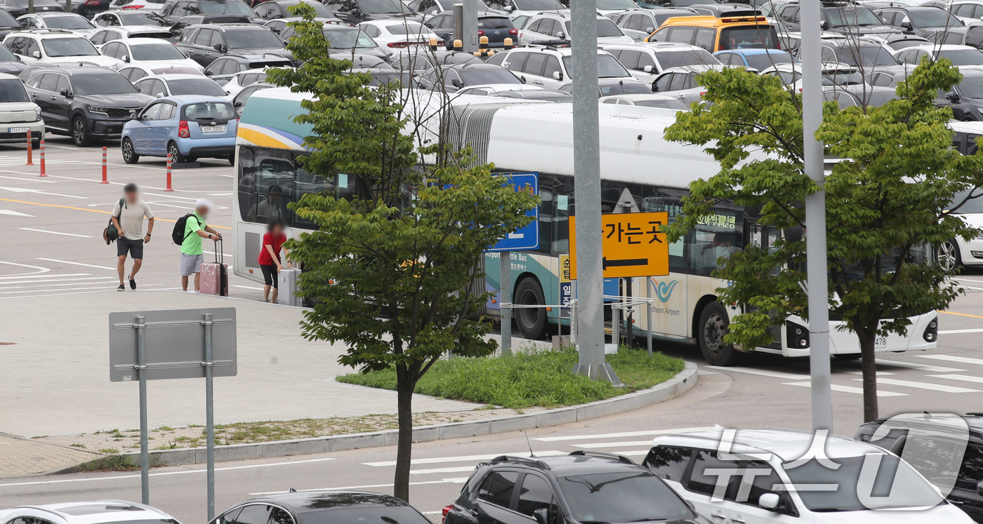 (인천공항=뉴스1) 이승배 기자 = 30일 인천국제공항 장기주차장에서 여행객들이 순환버스에 탑승하고 있다.한편 민주노총 공공운수노조 인천공항지역지부 조합원들은 이날 인천공항 2터미 …