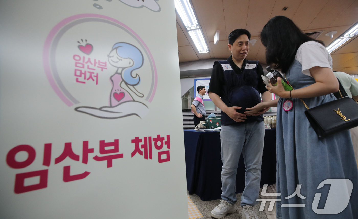 (서울=뉴스1) 오대일 기자 = 30일 서울 영등포구 여의도역 대합실에서 열린 서울교통공사의 임산부 배려 캠페인에서 출산을 앞둔 한 부부가 임산부 체험을 하고 있다.임산부 배려문화 …