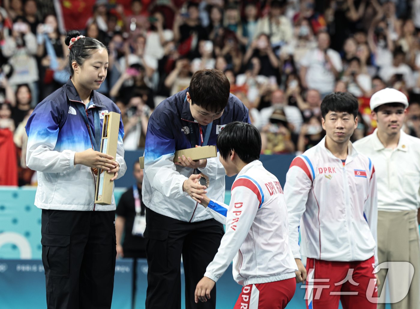본문 이미지 - 대한민국 탁구 대표팀 신유빈, 임종훈 선수가 30일(한국시간) 프랑스 파리 사우스 파리 아레나4에서 열린 '2024 파리올림픽' 탁구 혼합복식 시상식에서 은메달을 획득한 북한 김금용 선수에게 축하 받고 있다. 2024.7.30/뉴스1 ⓒ News1 이동해 기자