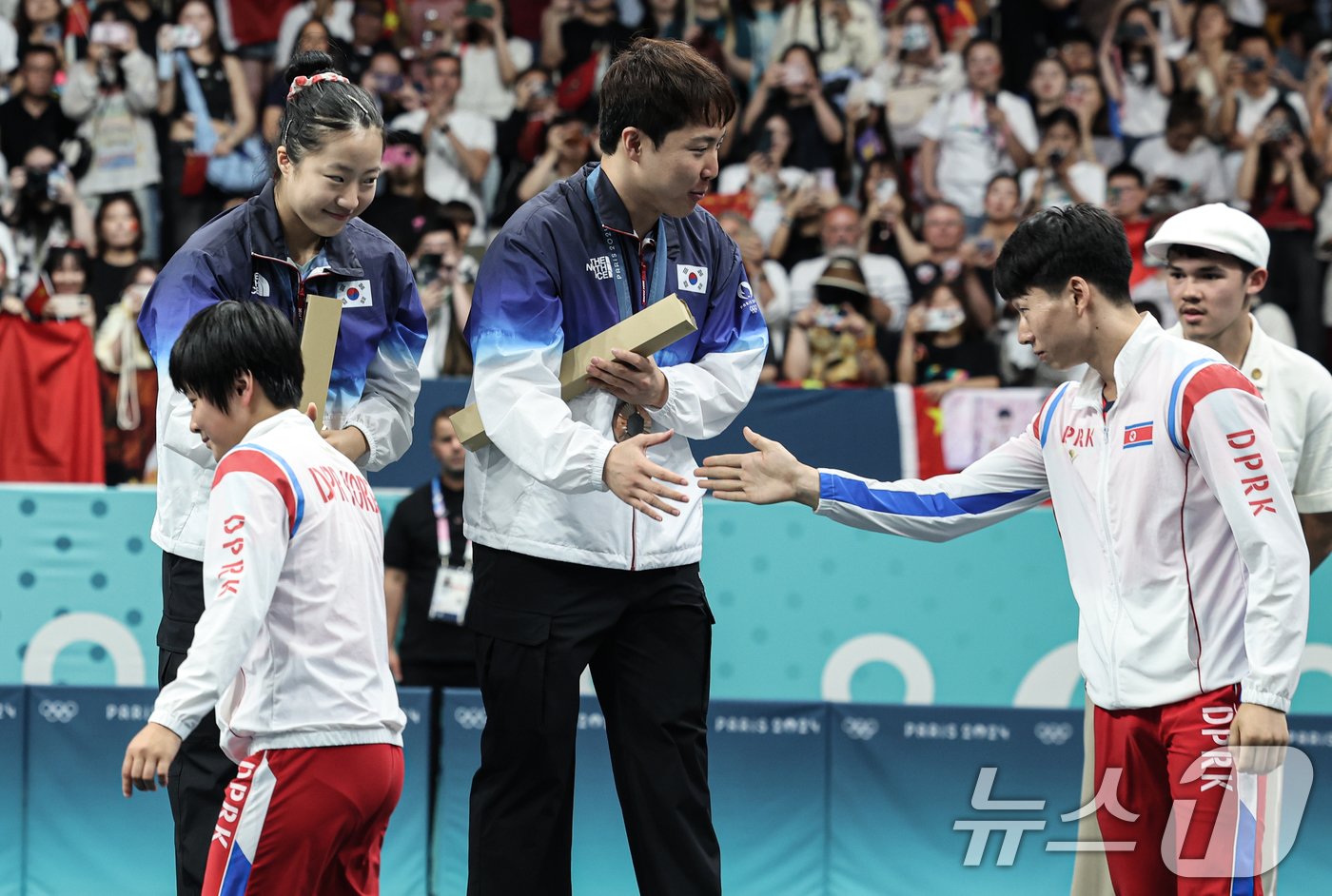 대한민국 탁구 대표팀 신유빈, 임종훈 선수가 30일&#40;한국시간&#41; 프랑스 파리 사우스 파리 아레나4에서 열린 &#39;2024 파리올림픽&#39; 탁구 혼합복식 시상식에서 은메달을 획득한 북한 김금용, 리종식 선수에게 축하 받고 있다. 2024.7.30/뉴스1 ⓒ News1 이동해 기자