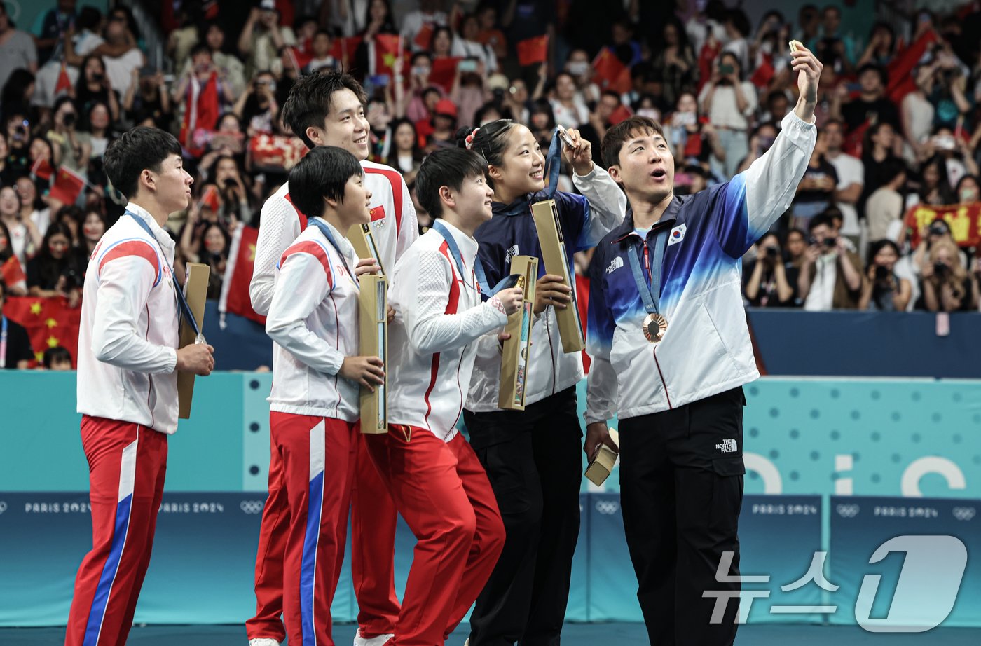 본문 이미지 - 대한민국 탁구 대표팀 신유빈, 임종훈 선수가 30일(한국시간) 프랑스 파리 사우스 파리 아레나4에서 열린 '2024 파리올림픽' 탁구 혼합복식 시상식에서 금메달을 획득한 중국 왕추친, 쑨잉사와 은메달을 획득한 북한 리종식, 김금용과 함께 기념촬영을 하고 있다. 2024.7.30/뉴스1 ⓒ News1 이동해 기자