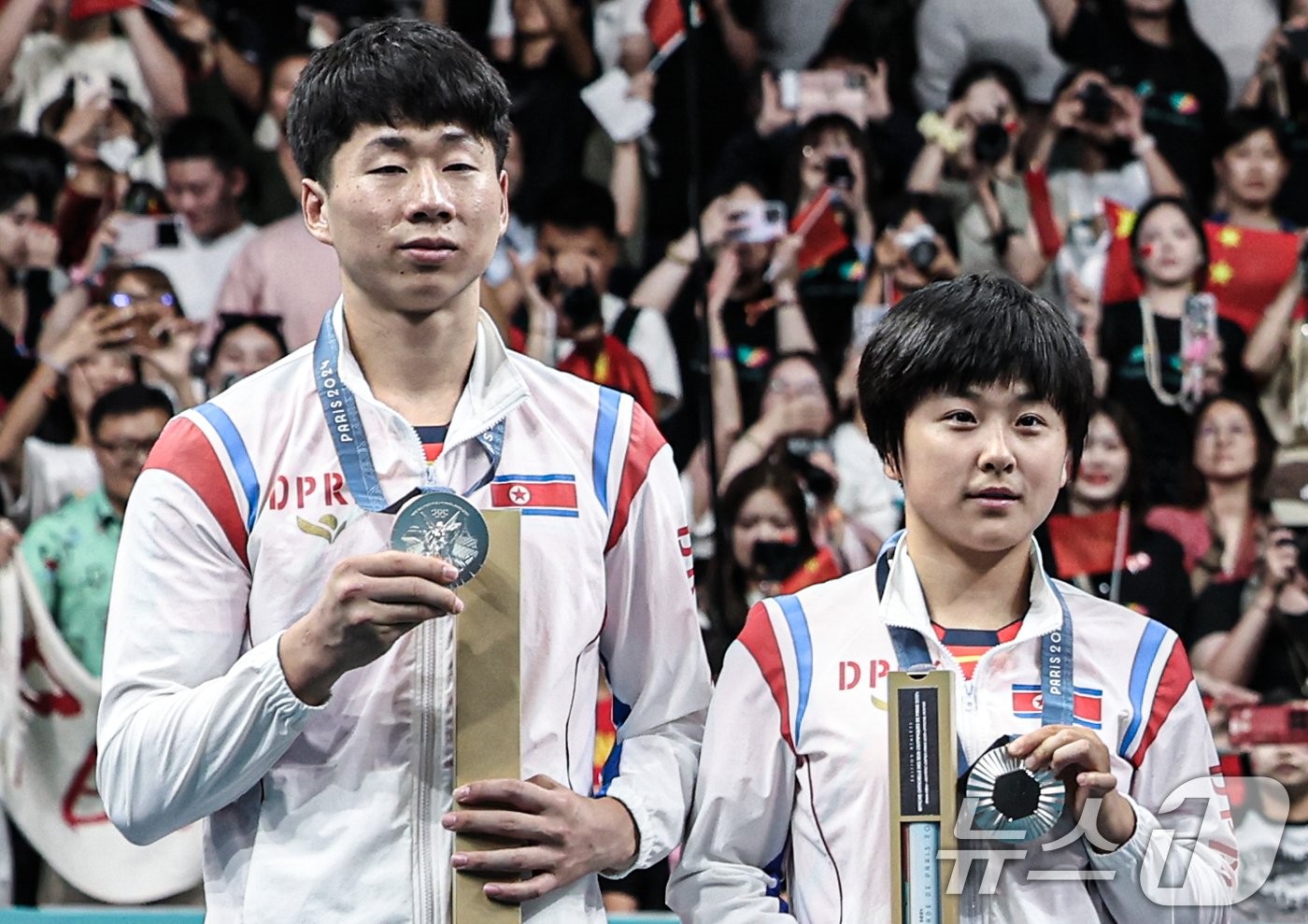본문 이미지 - 북한 탁구 대표팀 리종식, 김금용 선수가 30일(한국시간) 프랑스 파리 사우스 파리 아레나4에서 열린 '2024 파리올림픽' 탁구 혼합복식 시상식에서 은메달을 들어보이고 있다. 2024.7.30/뉴스1 ⓒ News1 이동해 기자
