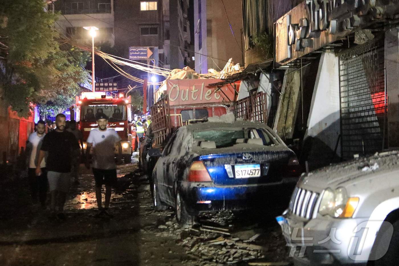 본문 이미지 - 30일(현지시간) 이스라엘이 레바논 베이루트의 남부 교외 지역을 공습한 뒤 부서진 건물 잔해 옆으로 시민들이 지나고 있다. 이날 이스라엘군은 골란고원에서 어린이 사망자를 낸 로켓공격에 책임이 있는 헤즈볼라 사령관이 공습 목표였다고 밝혔다. 2024.07.30. ⓒ AFP=뉴스1 ⓒ News1 김종훈 기자