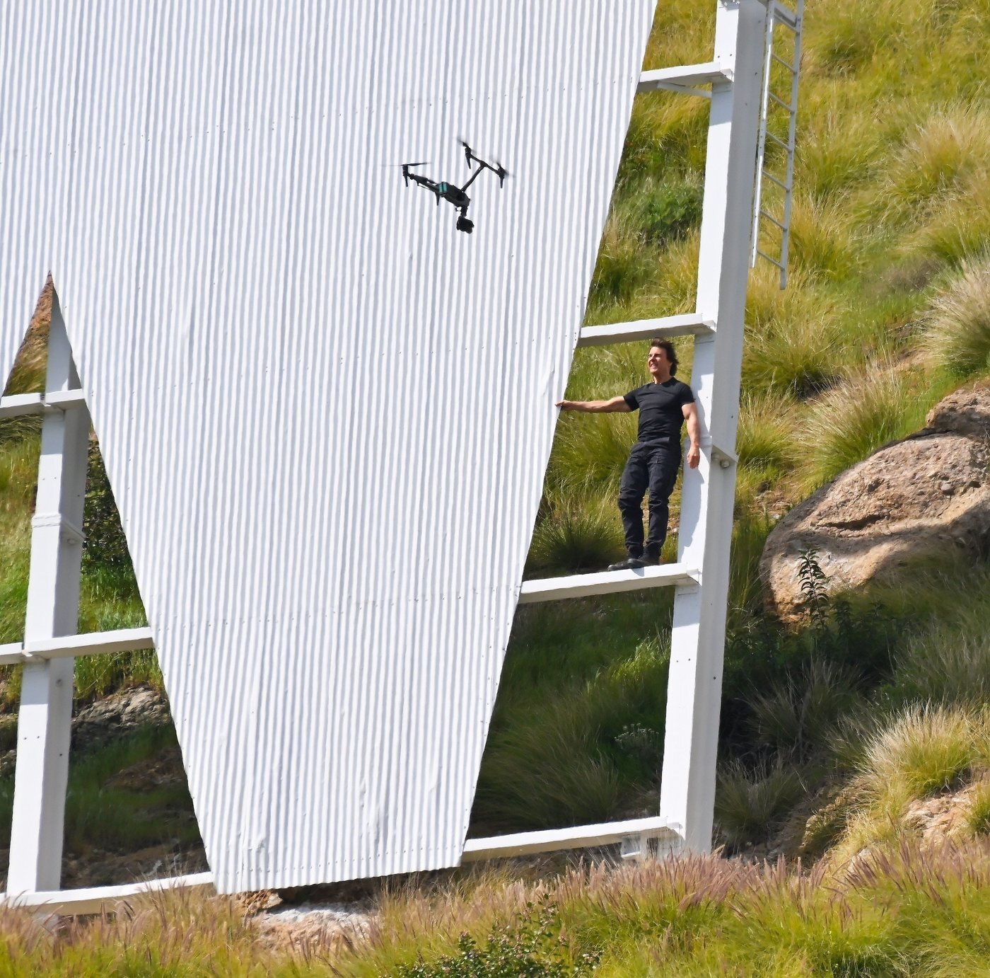 본문 이미지 - 지난 3월 톰 크루즈가 미국 캘리포니아주 로스앤젤레스의 명물 '할리우드 사인'에 올라 촬영하고 있는 모습. <출처= 엑스 갈무리>