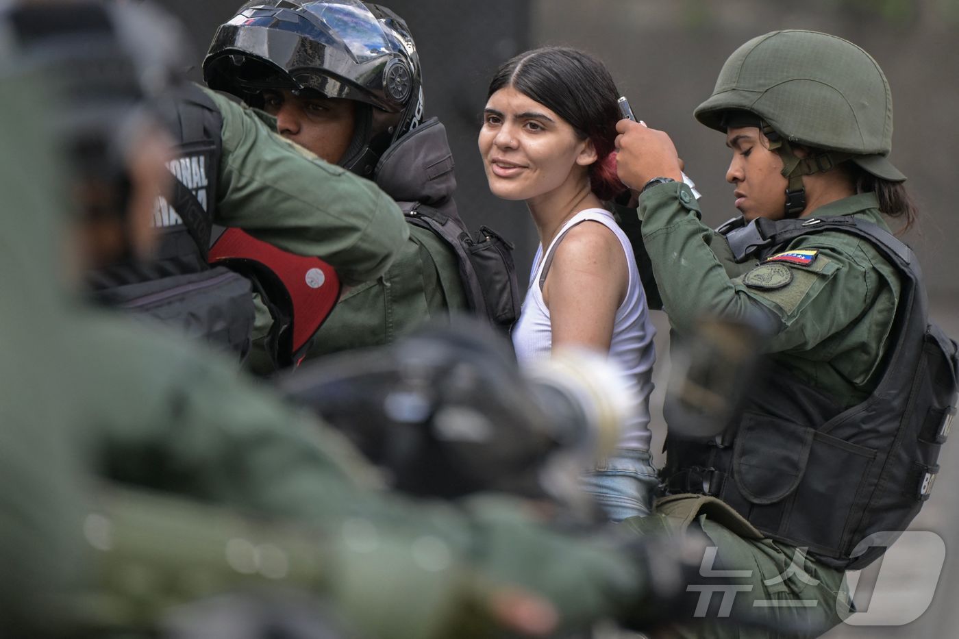 본문 이미지 - 30일(현지시간) 베네수엘라 야권 지도자 마리아 코리나 마차도와 에드문도 곤살레스 우루티아 대통령 후보의 지지자가 카라카스에서 열린 대통령 선거 결과에 불복하는 시위에 참석 중 진압군에 체포되고 있다. 2024.07.31 ⓒ AFP=뉴스1 ⓒ News1 우동명 기자