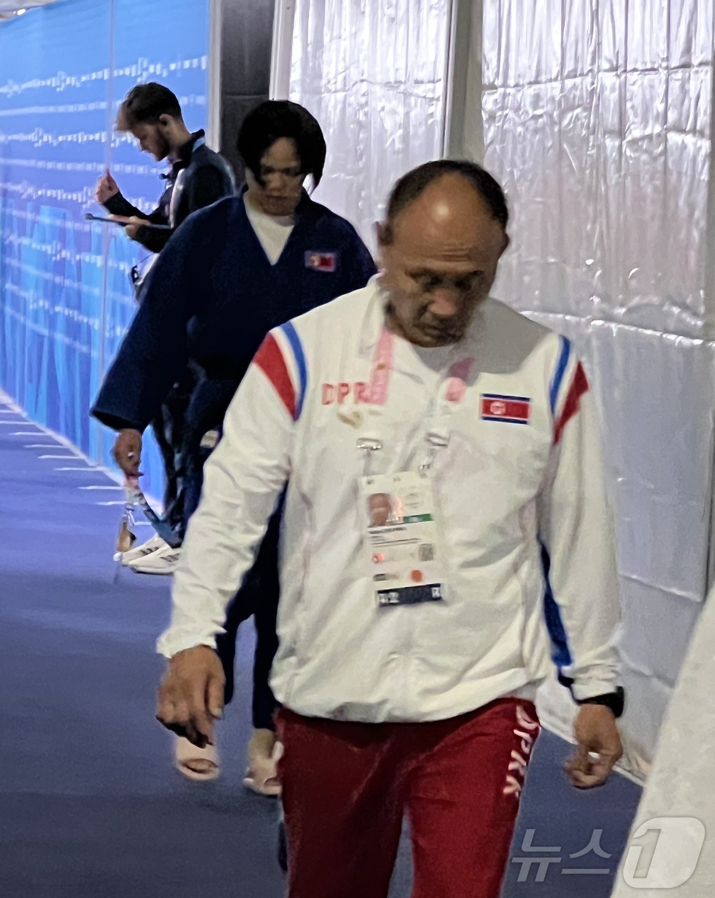 본문 이미지 - 북한 유도 국가대표 문성희가 31일 오후(한국시간) 열린 2024 파리 올림픽 유도 여자 70㎏급 32강에서 패한 뒤 북한 유도 대표팀 지도자와 함께 퇴장하고 있다. 2024.7.31/뉴스1 ⓒ News1 이상철 기자