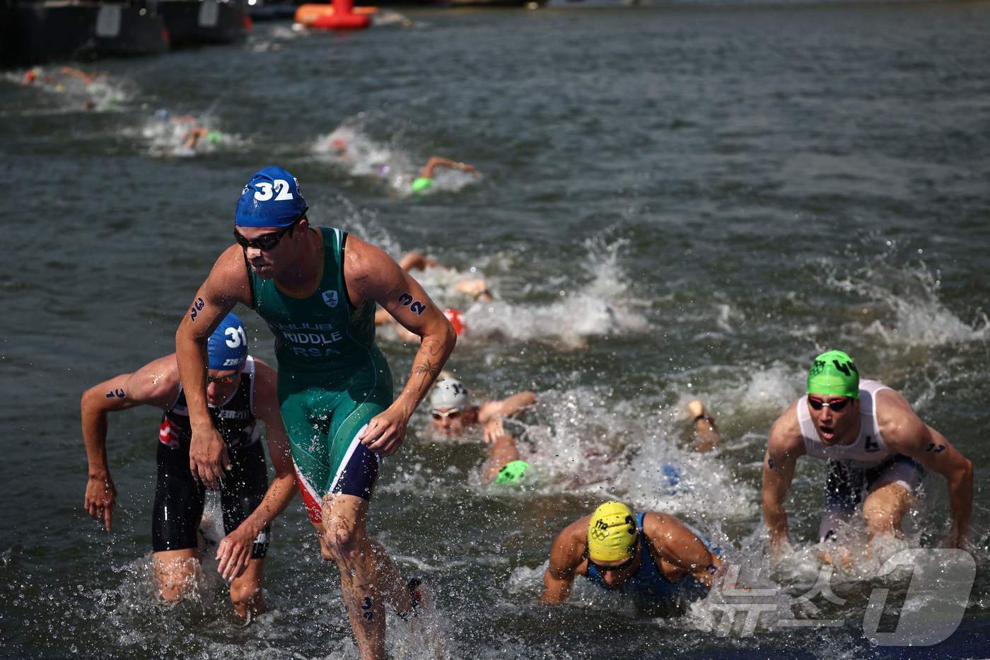 본문 이미지 - 센강에서 열린 트라이애슬론에서 선수들이  수영을 마치고 나오고 있다. ⓒ AFP=뉴스1