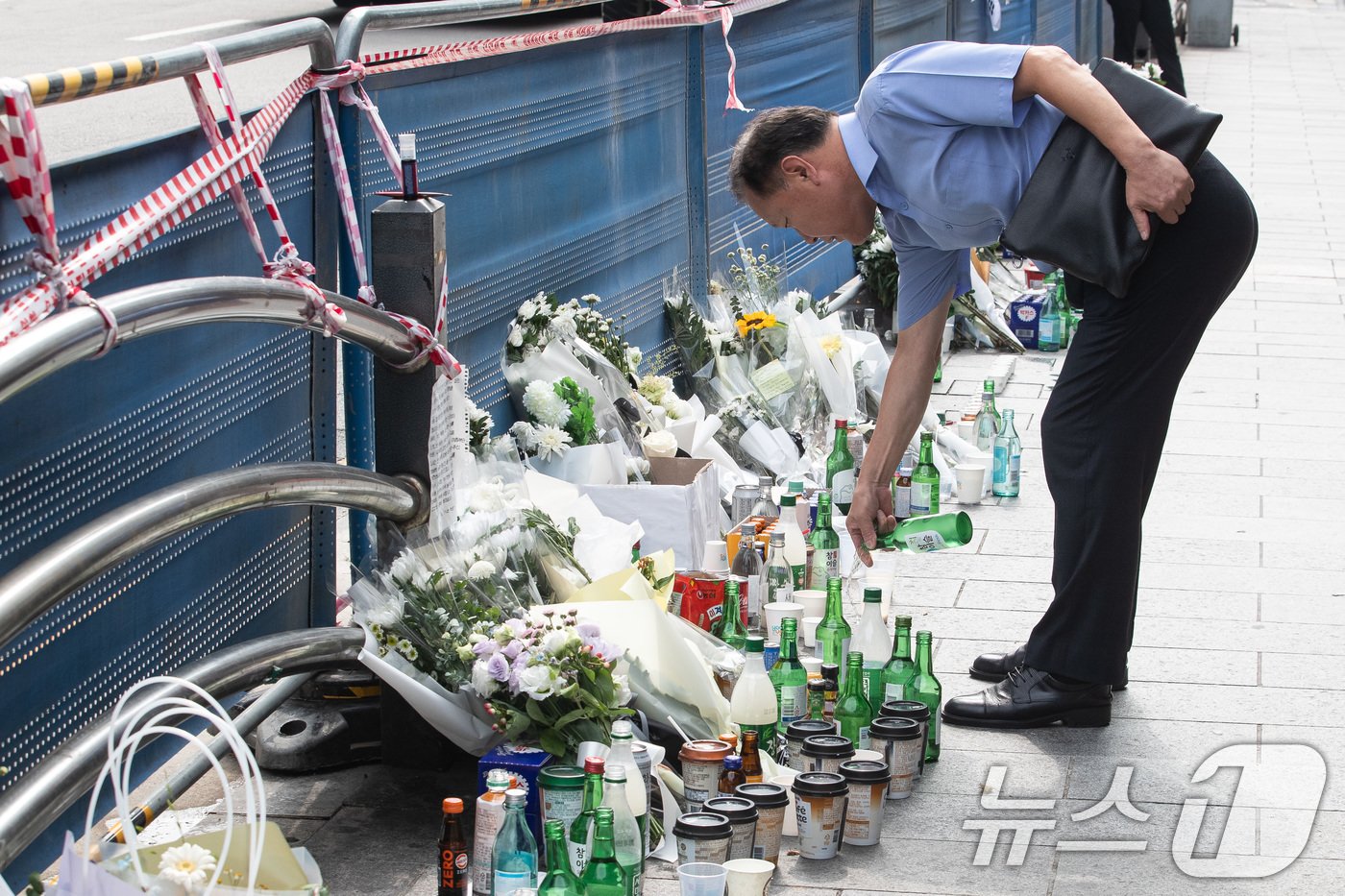 본문 이미지 - 4일 서울 중구 시청역 인근 역주행 교통사고 현장에서 한 시민이 희생자를 추모하며 술을 놓고 있다. 2024.7.4/뉴스1 ⓒ News1 유승관 기자