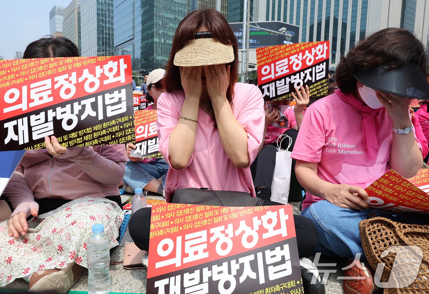 본문 이미지 - 한국유방암환우총연합회·한국환자단체연합회·한국희귀난치성질환연합회 등 총 92개 환자단체 회원들이 지난 2024년 7월 4일 4일 오전 서울 종로구 보신각 앞에서 열린 '의사 집단휴진 철회 및 재발방지법 제정 환자촉구대회'에서 눈물을 닦고 있다. 2024.7.4/뉴스1 ⓒ News1 김진환 기자