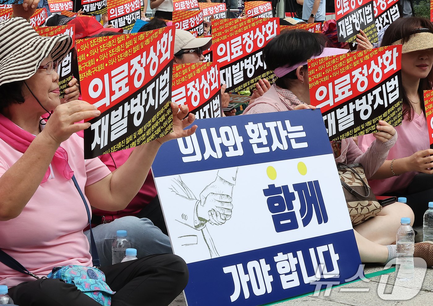 한국유방암환우총연합회·한국환자단체연합회·한국희귀난치성질환연합회 등 총 92개 환자단체 회원들이 4일 오전 서울 종로구 보신각 앞에서 열린 &#39;의사 집단휴진 철회 및 재발방지법 제정 환자촉구대회&#39;에서 피켓을 들고 있다. 2024.7.4/뉴스1 ⓒ News1 김진환 기자