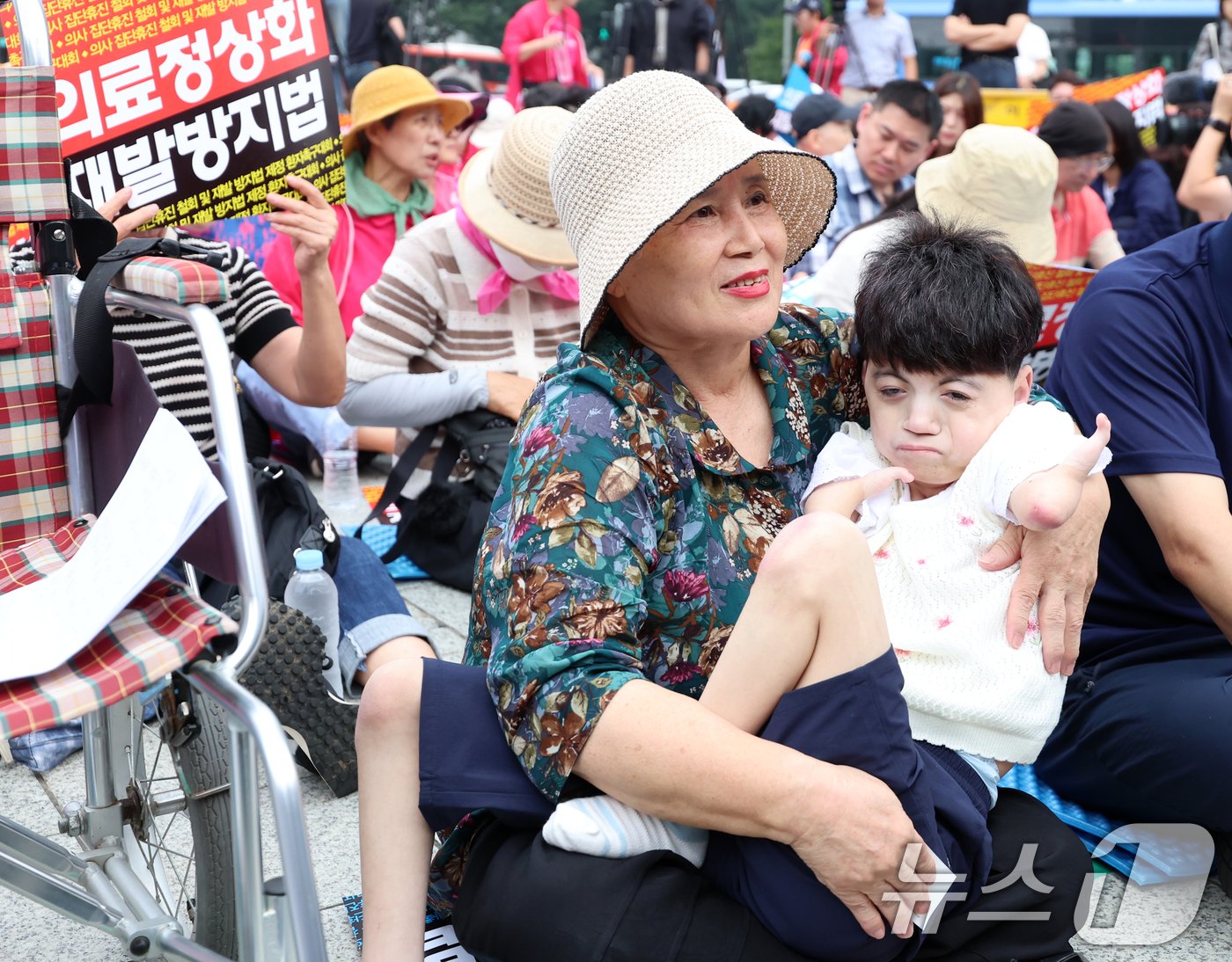 본문 이미지 - 코넬리아드랑게 증후군을 앓고 있는 박하은씨와 어머니 김정애씨가 4일 오전 서울 종로구 보신각 앞에서 한국유방암환우총연합회·한국환자단체연합회·한국희귀난치성질환연합회 등 총 92개 환자단체 주최로 열린 '의사 집단휴진 철회 및 재발방지법 제정 환자촉구대회'에 참석하고 있다. 2024.7.4/뉴스1 ⓒ News1 김진환 기자