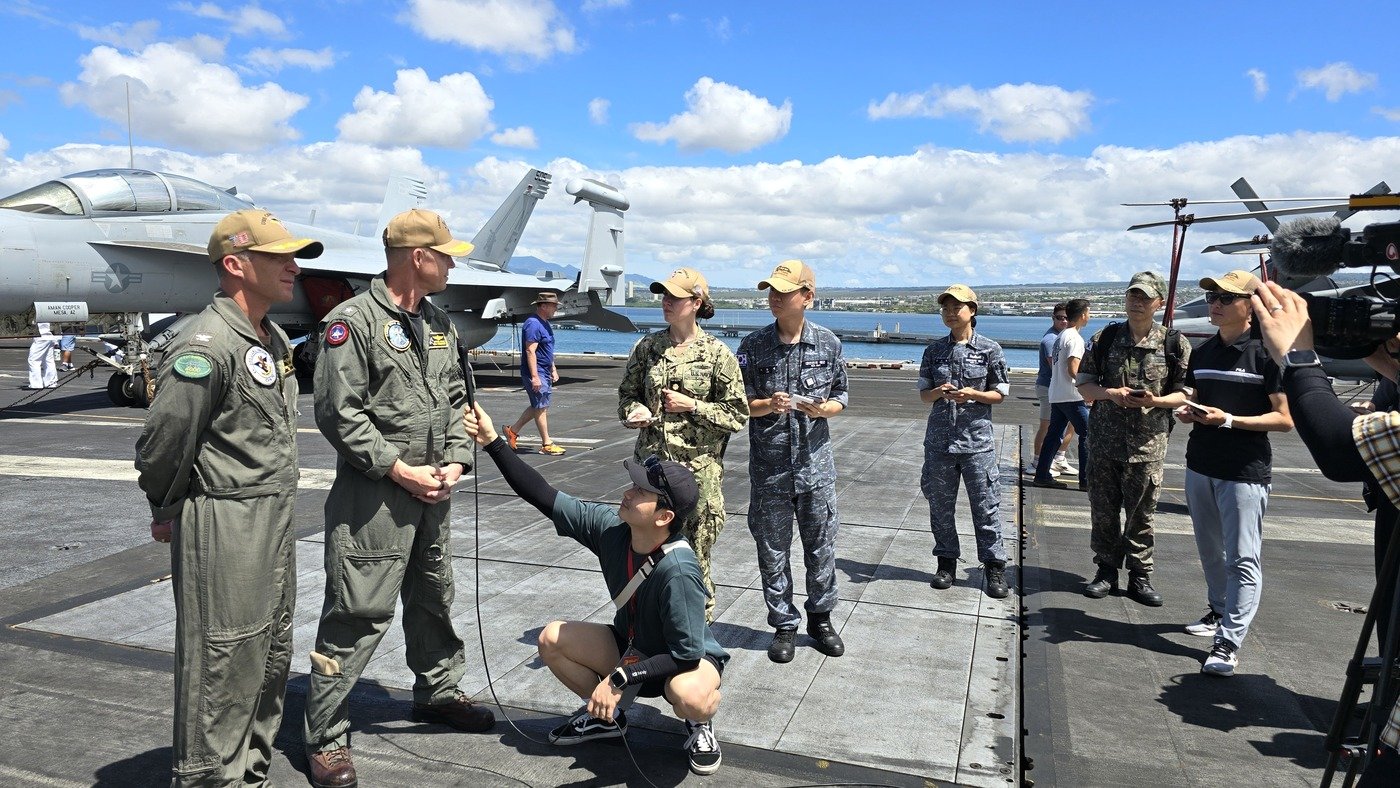 본문 이미지 - 6일(현지시각) 하와이 진주만 히캄 기지에 정박 중인 미국 해군의 니미츠급 원자력 추진 항공모함 '칼빈슨'에서 한국 취재진과 마이클 워시 미 해군 제1항모강습단장(오른쪽) 및 매튜 토마스 칼빈슨함장 간 인터뷰를 지원하고 있는 이윤재 병장(왼쪽에서 4번째).