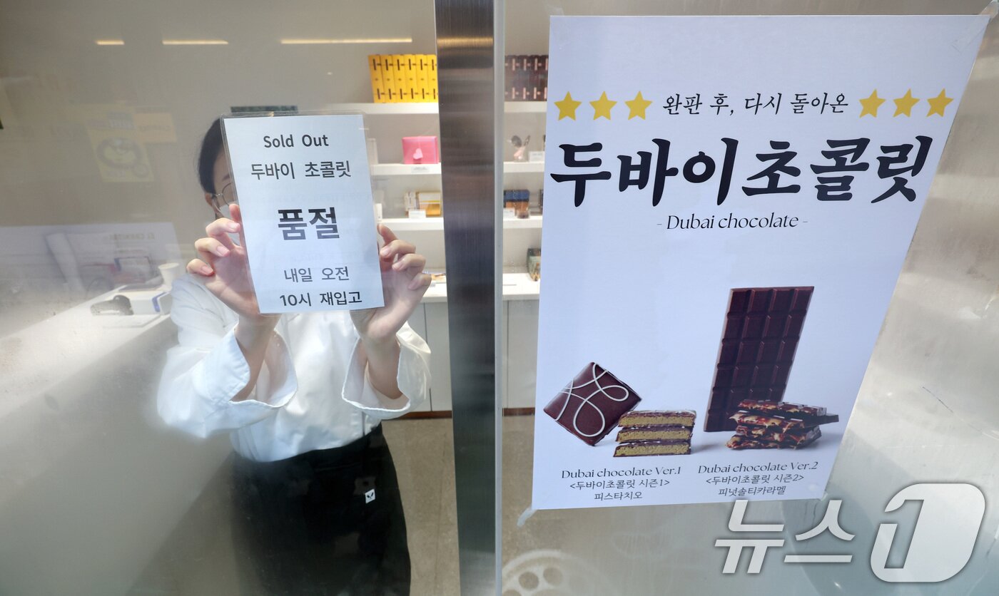본문 이미지 - 숏폼을 타고 유행 중인 두바이 초콜릿이 &#39;품귀 대란&#39;을 겪고 있는 가운데 8일 서울의 한 두바이 초콜릿 판매점 입구에서 직원이 품절 안내문을 붙이고 있다. 2024.7.8/뉴스1 ⓒ News1 이동해 기자