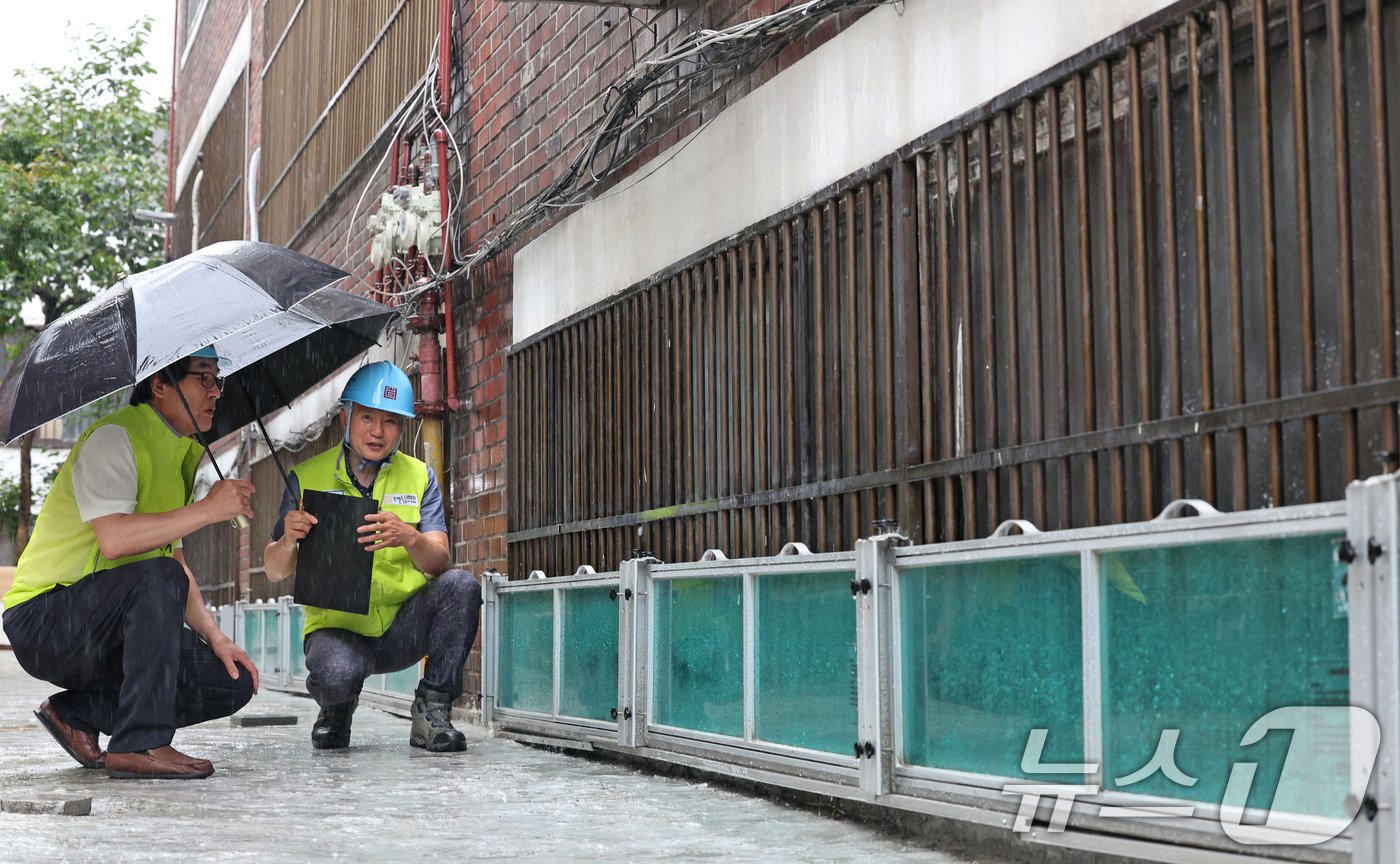 본문 이미지 - 서울시건축사회 관계자들이 8일 오후 서울 관악구의 침수 우려 주택가에서 지난해 반지하세대 창문에 설치된 수해예방용 물막이판의 이상 유무를 점검하고 있다.. 2024.7.8/뉴스1 ⓒ News1 장수영 기자