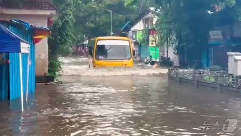 본문 이미지 - 8일(현지시간) 인도 뭄바이에 폭우가 내린 가운데 안데리 지하철 근처 침수된 도로를 버스가 헤치고 지나가는 모습.(PTI통신 갈무리).