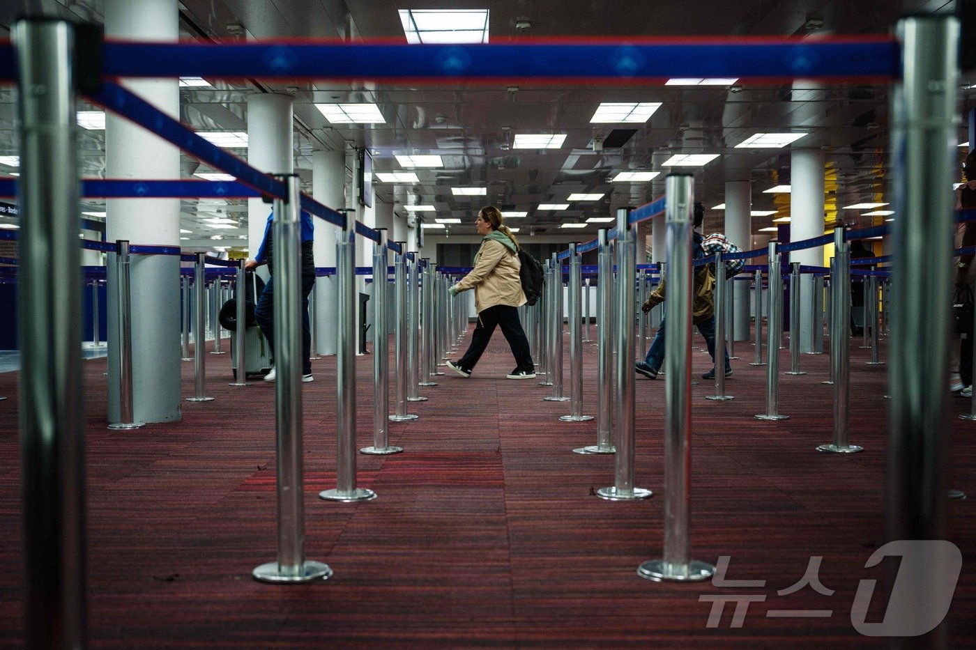 본문 이미지 - 3일(현지시간) 파리 북쪽에 위치한 루아시앙프랑스에서 열리는 '2024 파리 올림픽'을 위해 외국인 방문객들의 국경 통제 완화 조치를 설명하는 동안 승객들이 샤를 드골 공항의 입국장으로 걸어 들어가고 있다.2024.07.03/ ⓒ AFP=뉴스1 ⓒ News1 이강 기자