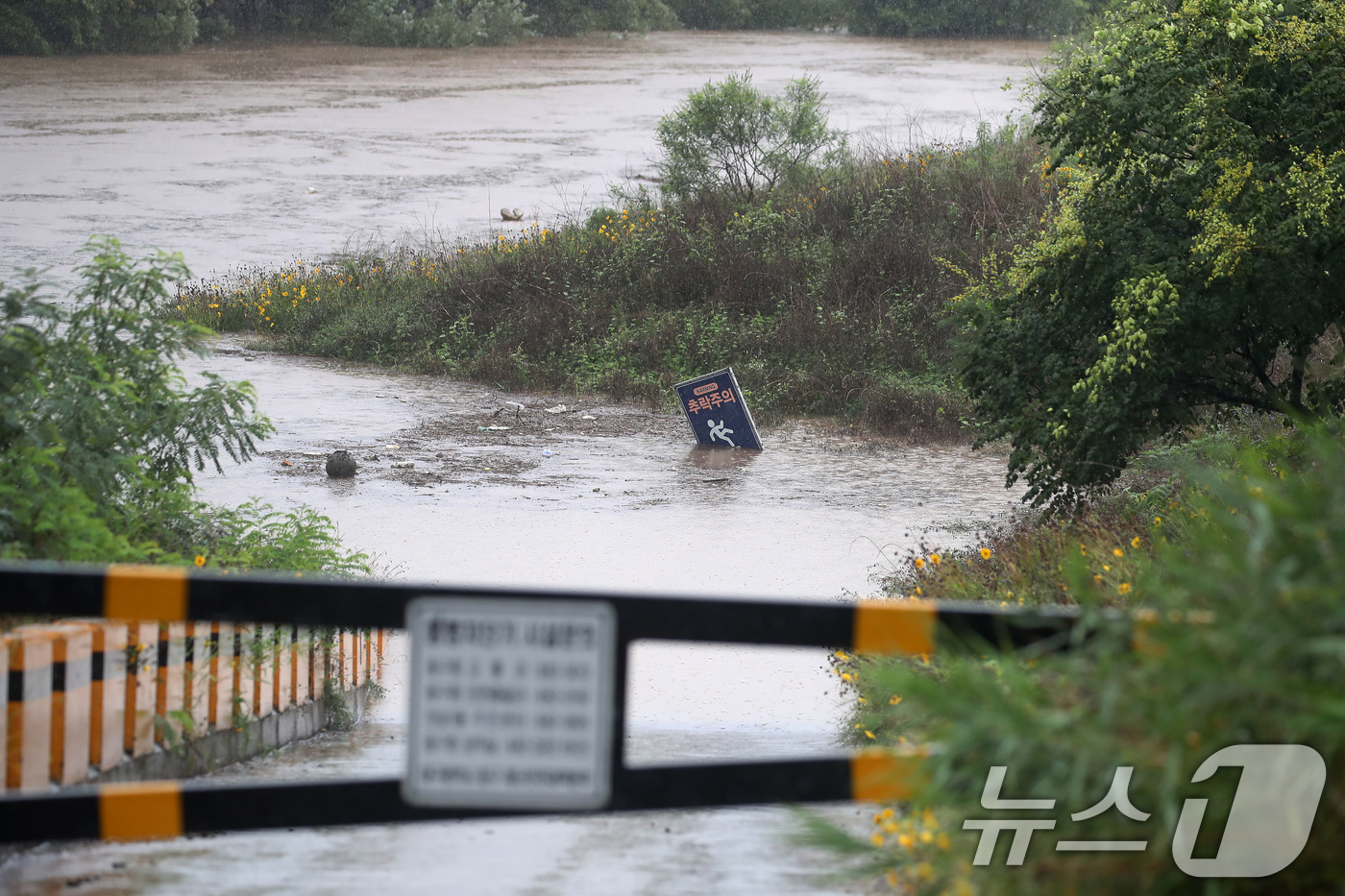(대구=뉴스1) 공정식 기자 = 밤사이 집중호우가 내린 9일 오전 대구 동구와 수성구를 잇는 금호강 가천잠수교가 침수돼 진입로가 통제되고 있다. 2024.7.9/뉴스1