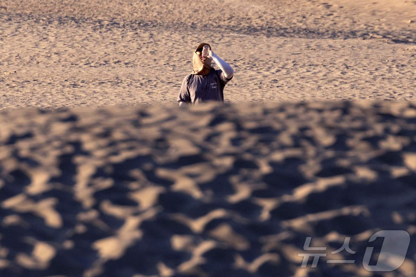 본문 이미지 - 7일(현지시간) 미국 캘리포니아 남부에 영향을 미친 폭염 속 데스밸리 국립공원에서 한 관광객이 물을 마시고 있다. 미국 국립기상청에 따르면 일요일 데스 밸리의 기온은 화씨 130&deg;F(섭씨 54&deg;C)까지 올라갈 수 있다.2024.07.07/ ⓒ AFP=뉴스1 ⓒ News1 이강 기자