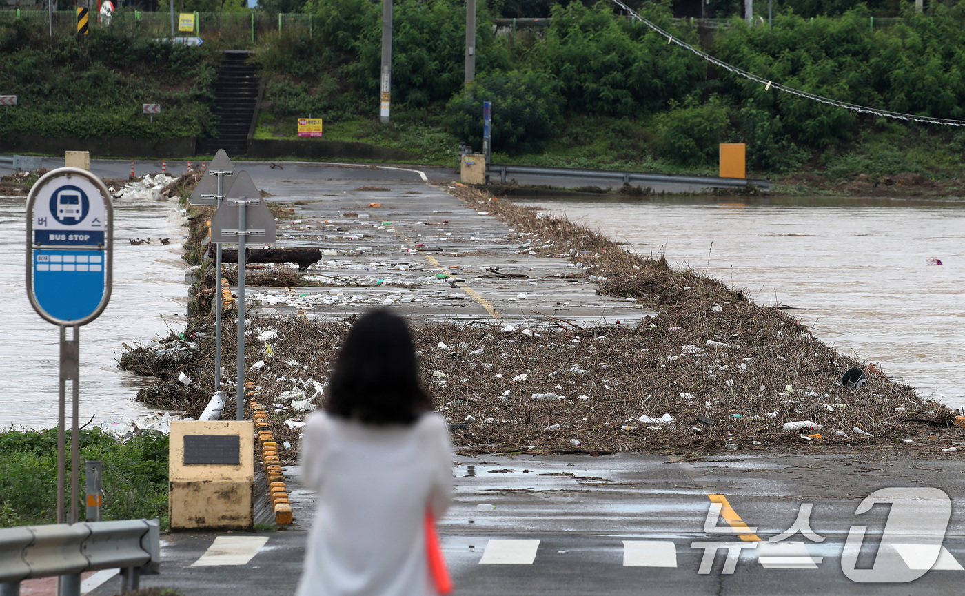(경산=뉴스1) 공정식 기자 = 집중호우가 내린 9일 오후 경북 경산시 하양읍 금호강 대부잠수교가 통제되고 있다. 상류에서 떠내려온 생활쓰레기를 비롯해 잡목과 토사 등이 잠수교 위 …