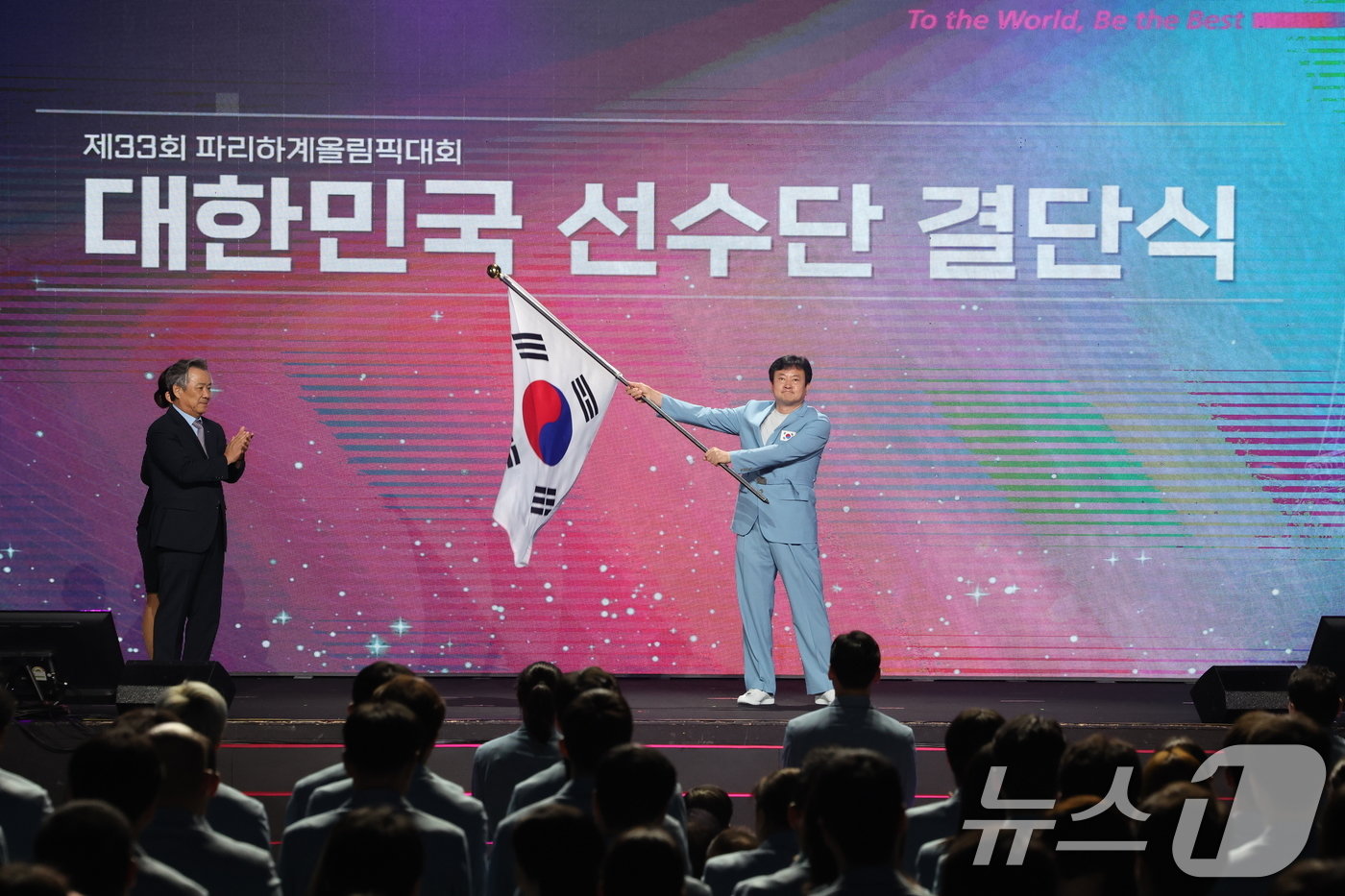 본문 이미지 - 정강선 파리올림픽 선수단장이 9일 오후 서울 송파구 올림픽공원 올림픽홀에서 열린 2024 파리하계올림픽대회 결단식에서 단기를 흔들고 있다. 2024.7.9/뉴스1 ⓒ News1 이동해 기자