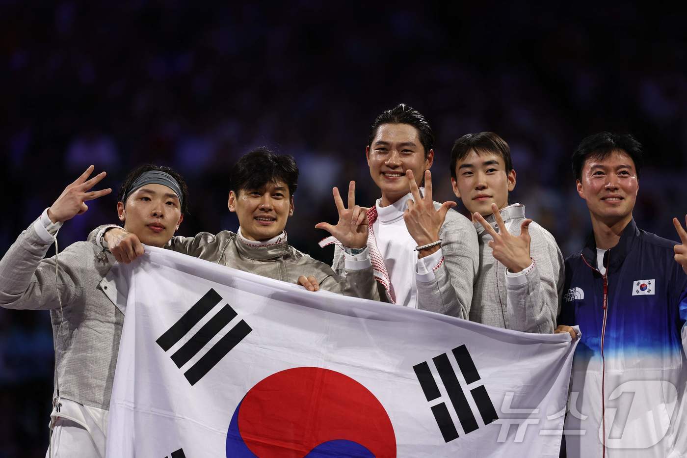 본문 이미지 - 펜싱 남자 사브르 대표팀과 감독이 31일(현지시간) 프랑스 파리에서 열린 2024 프랑스 올림픽 단체전에서 우승한 뒤 손가락으로 3연패를 의미하는 '3'을 펴보이는 세리머니를 하고 있다. 2024.07.31. ⓒ AFP=뉴스1 ⓒ News1 김종훈 기자