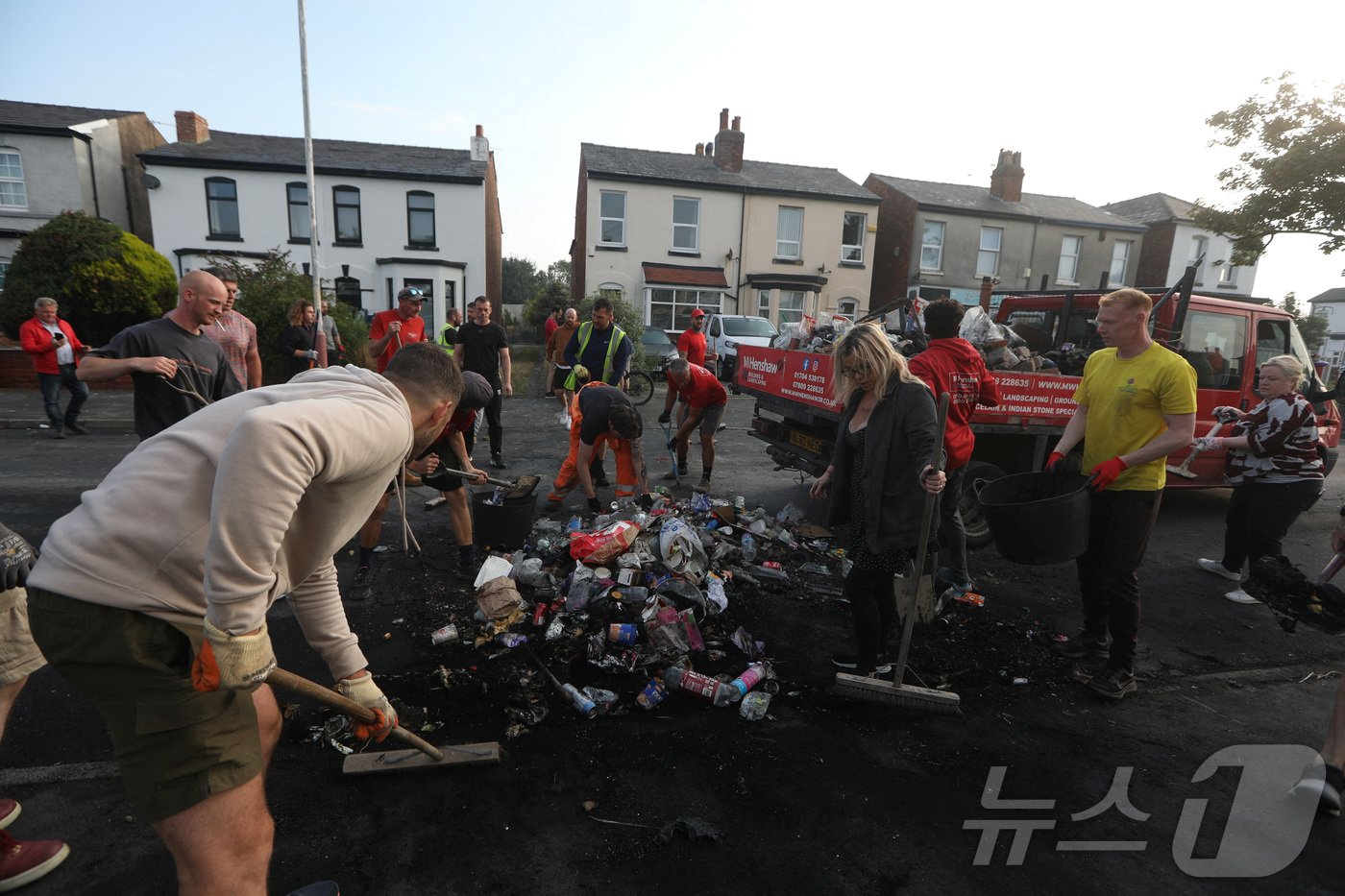 본문 이미지 - 31일(현지시간) 영국 사우스포트에서 자원봉사자들이 도로 위 쓰레기를 치우고 있다. 2024.07.31/ ⓒ 로이터=뉴스1 ⓒ News1 권진영 기자