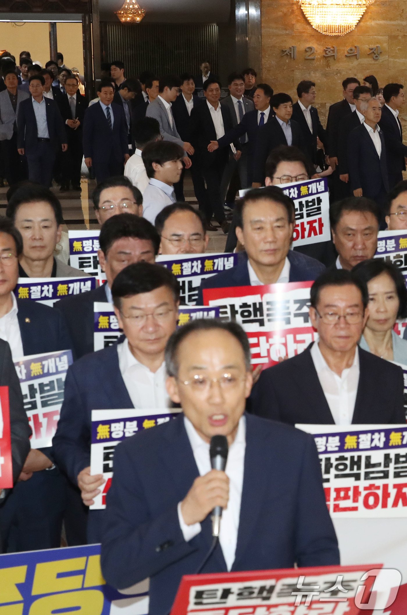 국민의힘 의원들이 1일 오후 서울 여의도 국회 로텐더홀 앞에서 본회의를 앞두고 더불어민주당 규탄대회를 하고 있는 가운데 의원총회를 마친 더불어민주당 의원들이 본회의장으로 들어가고 있다. 이날 본회의에서는 &#39;노란봉투법&#39;과 &#39;전국민 25만원 지원법&#39;이 상정되고 이진숙 방송통신위원장 탄핵소추안이 보고될 예정이다. 2024.8.1/뉴스1 ⓒ News1 이광호 기자