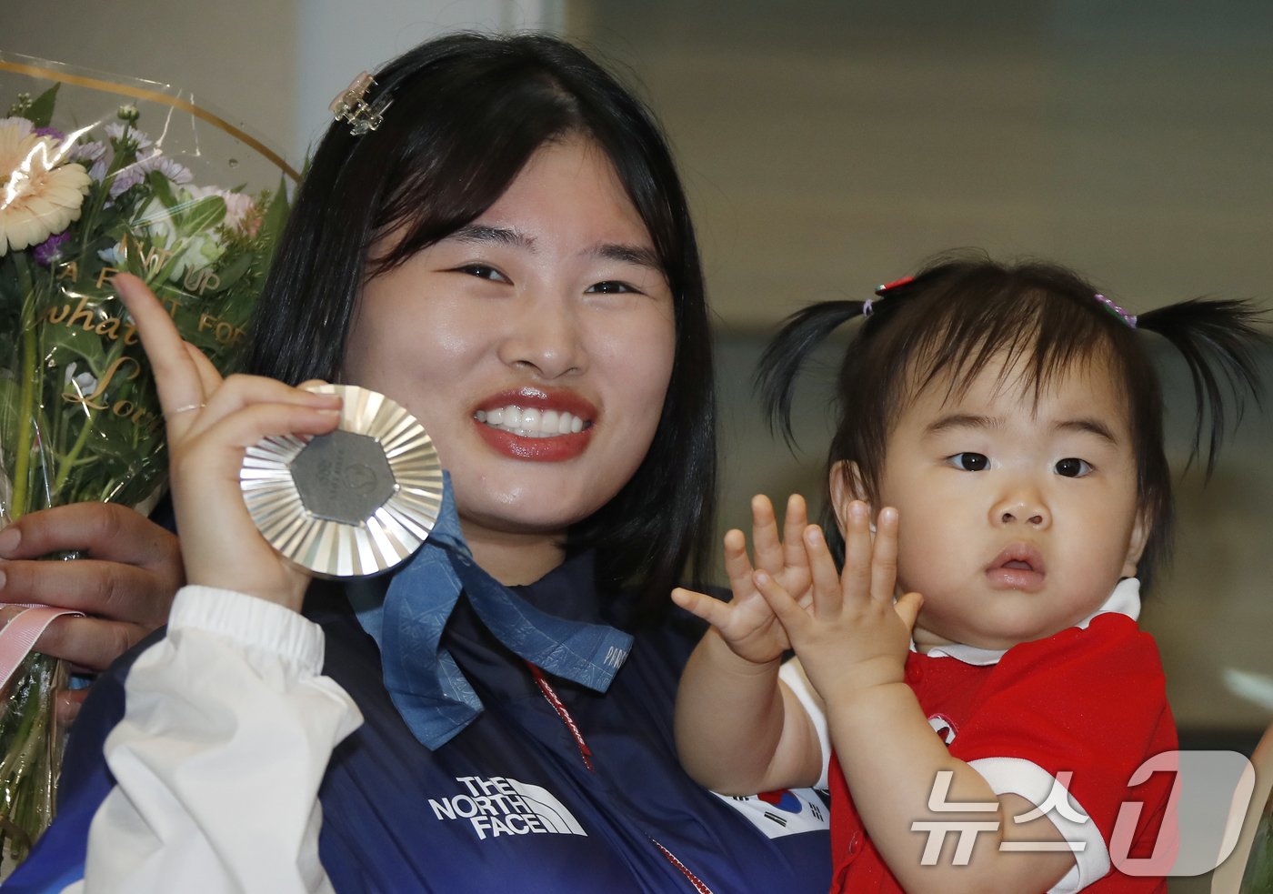 사격 국가대표 금지현이 1일 인천국제공항을 통해 프랑스 파리에서 입국해 딸 서아양을 안고 은메달을 들어 보이고 있다. 금지현은 박하준과 함께 27일&#40;현지시간&#41; 프랑스 샤토루 슈팅 센터에서 열린 2024 파리올림픽 사격 공기소총 10m 혼성 단체 시상식에서 은메달을 목에 걸었다. 2024.8.1./뉴스1 ⓒ News1 권현진 기자