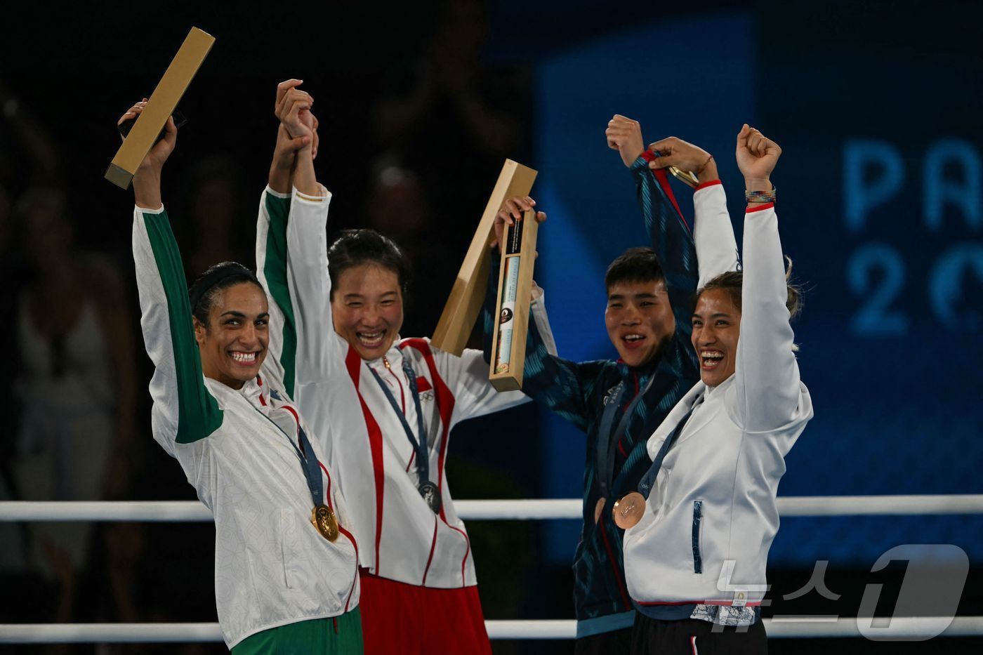 본문 이미지 - 성별 논란 끝에 여자 복싱 금메달을 획득한 알제리의 칼리프가 다른 메달리스트와 함께 환호하고 있다 ⓒ AFP=뉴스1