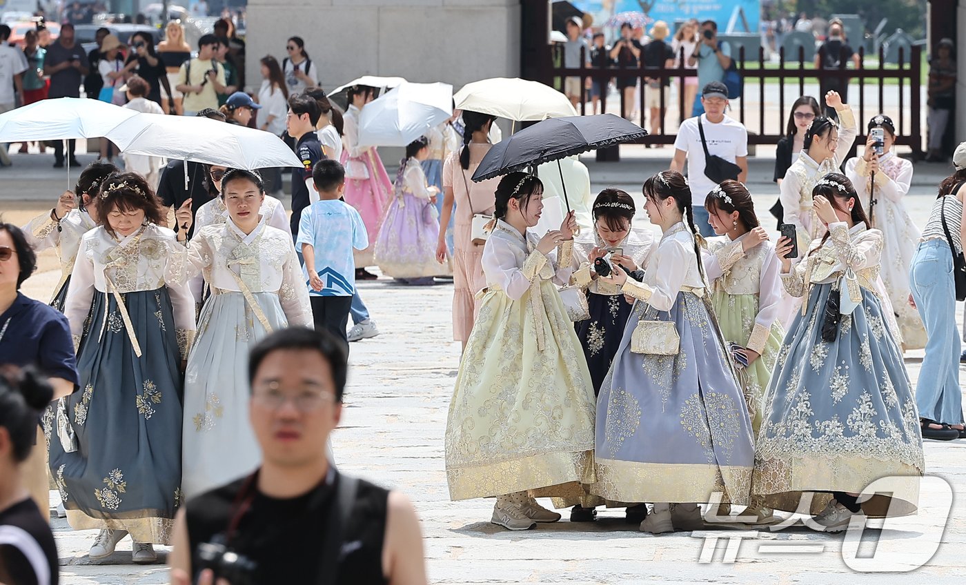 본문 이미지 - 전국 대부분 지역에 폭염특보가 발효된 11일 오후 서울 종로구 경복궁에서 외국인 관람객들이 양산을 쓰며 더위를 피하고 있다. 2024.8.11/뉴스1 ⓒ News1 김진환 기자