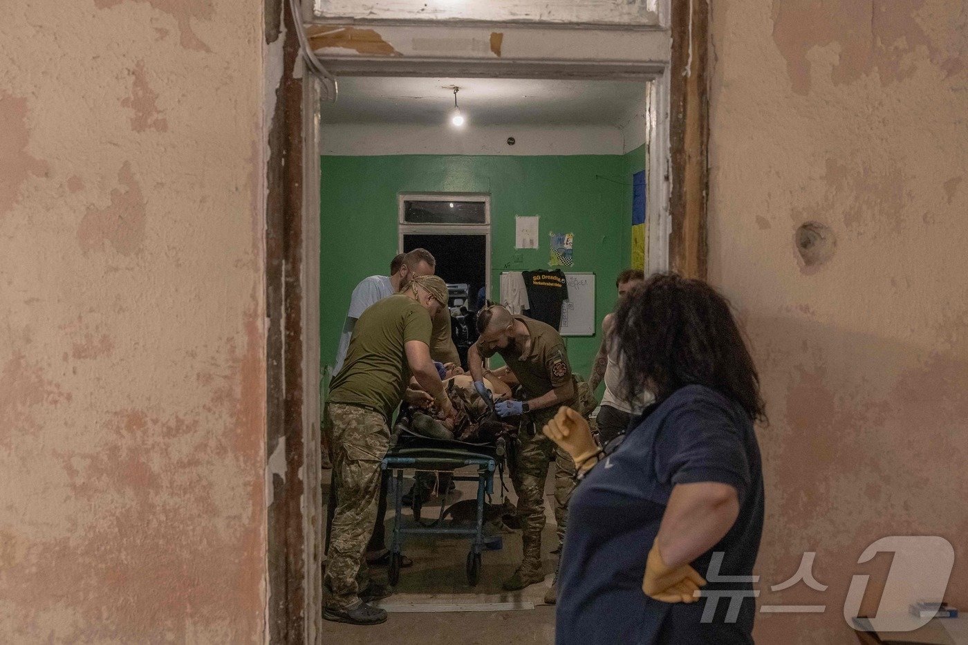 본문 이미지 - 6일(현지시간) 우크라이나 도네츠크주 동부의 포크로우스크에 위치한 우크라이나 육군 제47기계화여단 '마구라' 소속 의무병이 부상병 치료에 열중하고 있다. ⓒ AFP=뉴스1 ⓒ News1 김지완 기자
