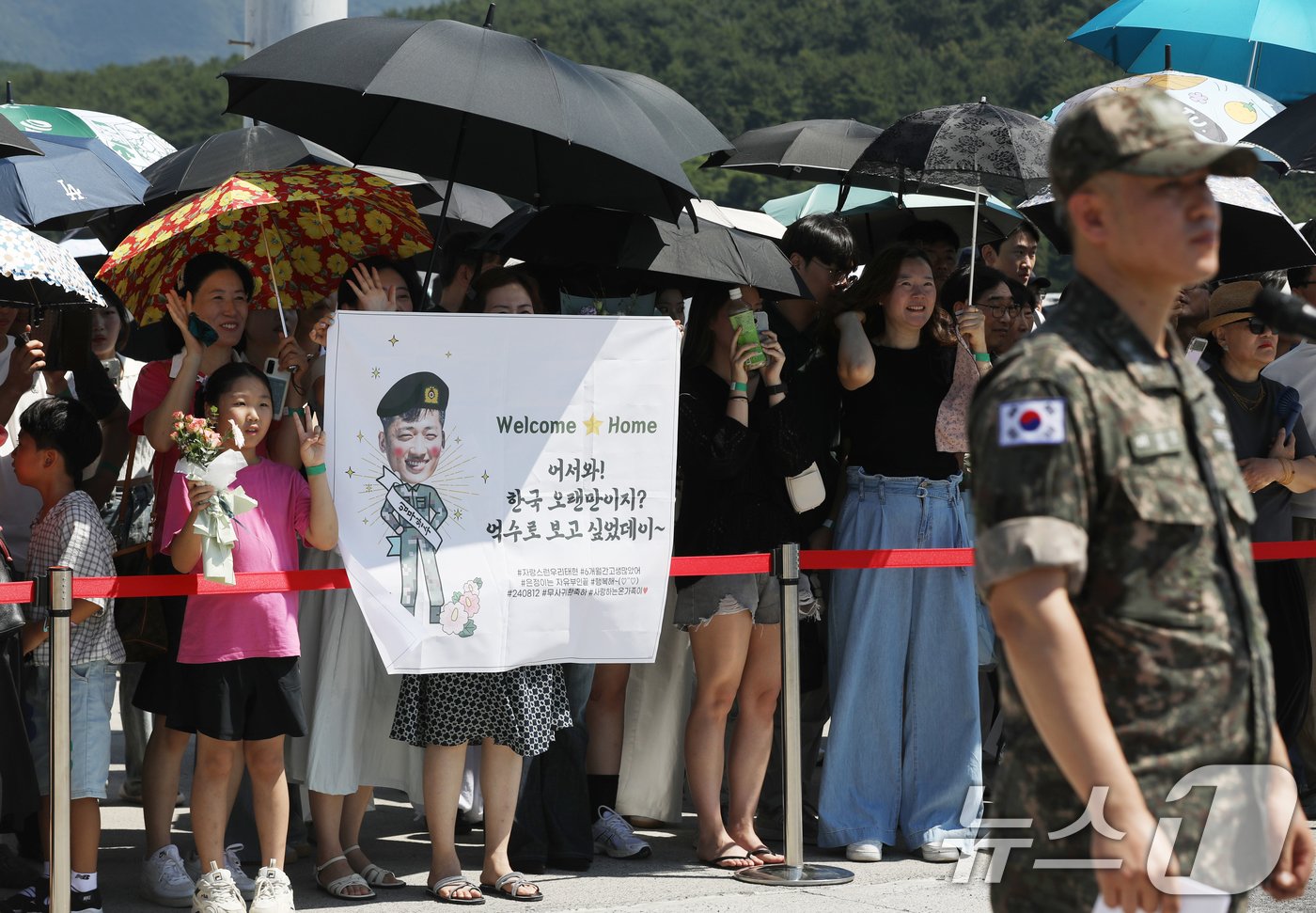본문 이미지 - 12일 경남 창원시 진해구 진해 군항에서 열린 청해부대 42진 대조영함(DDH-Ⅱ·4400톤급) 파병 복귀 환영 행사에서 가족들이 양산을 쓴 가족들이 청해부대원을 기다리고 있다. 2024.8.12/뉴스1 ⓒ News1 윤일지 기자