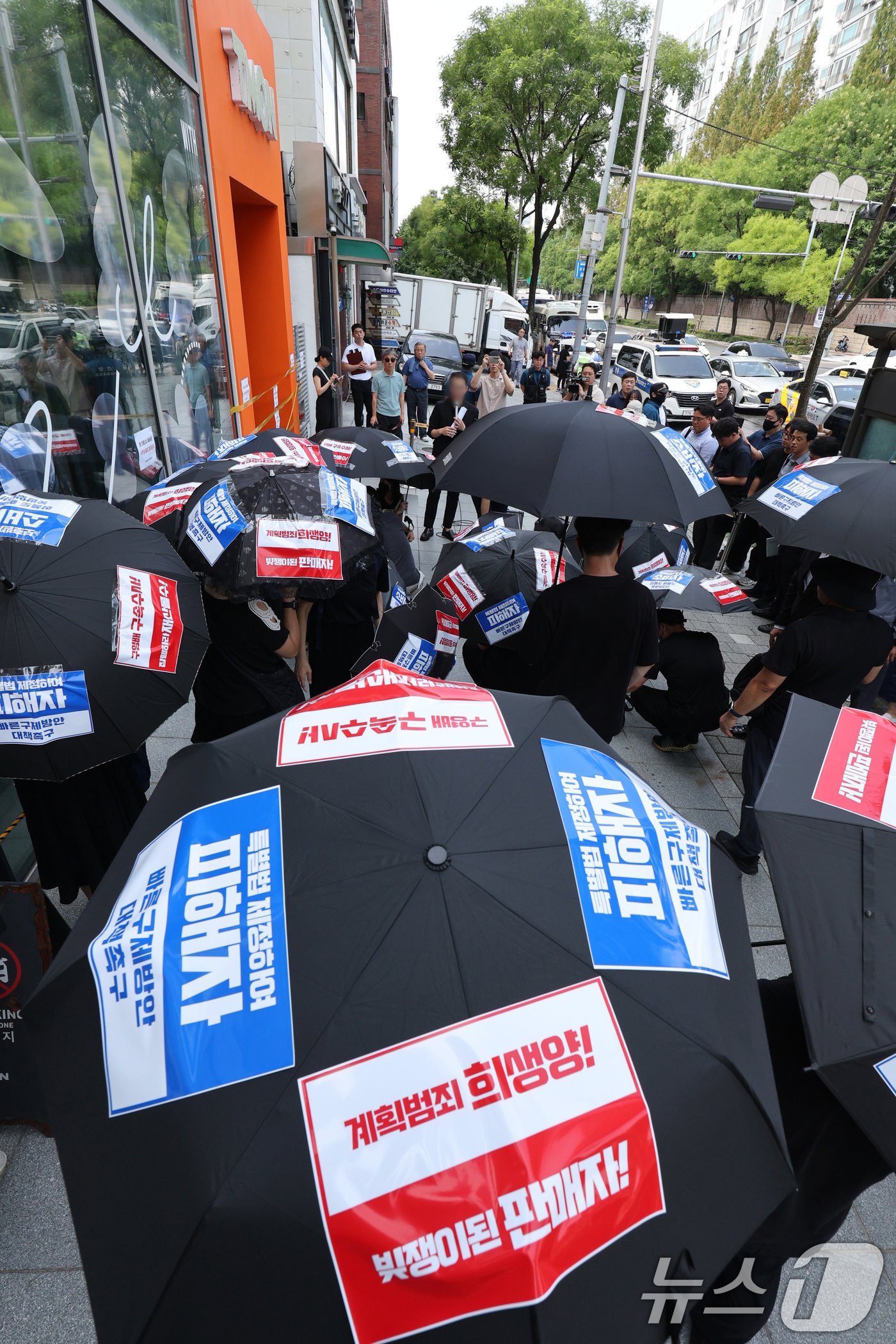 본문 이미지 - 티몬·위메프 사태 피해자들이 13일 오전 서울 강남구 티몬 사옥 앞에서 조속한 정산 및 환불 조치, 구영배 큐텐 회장 등 관련자 수사를 촉구하는 검은 우산 집회를 하고 있다. 2024.8.13/뉴스1 ⓒ News1 장수영 기자