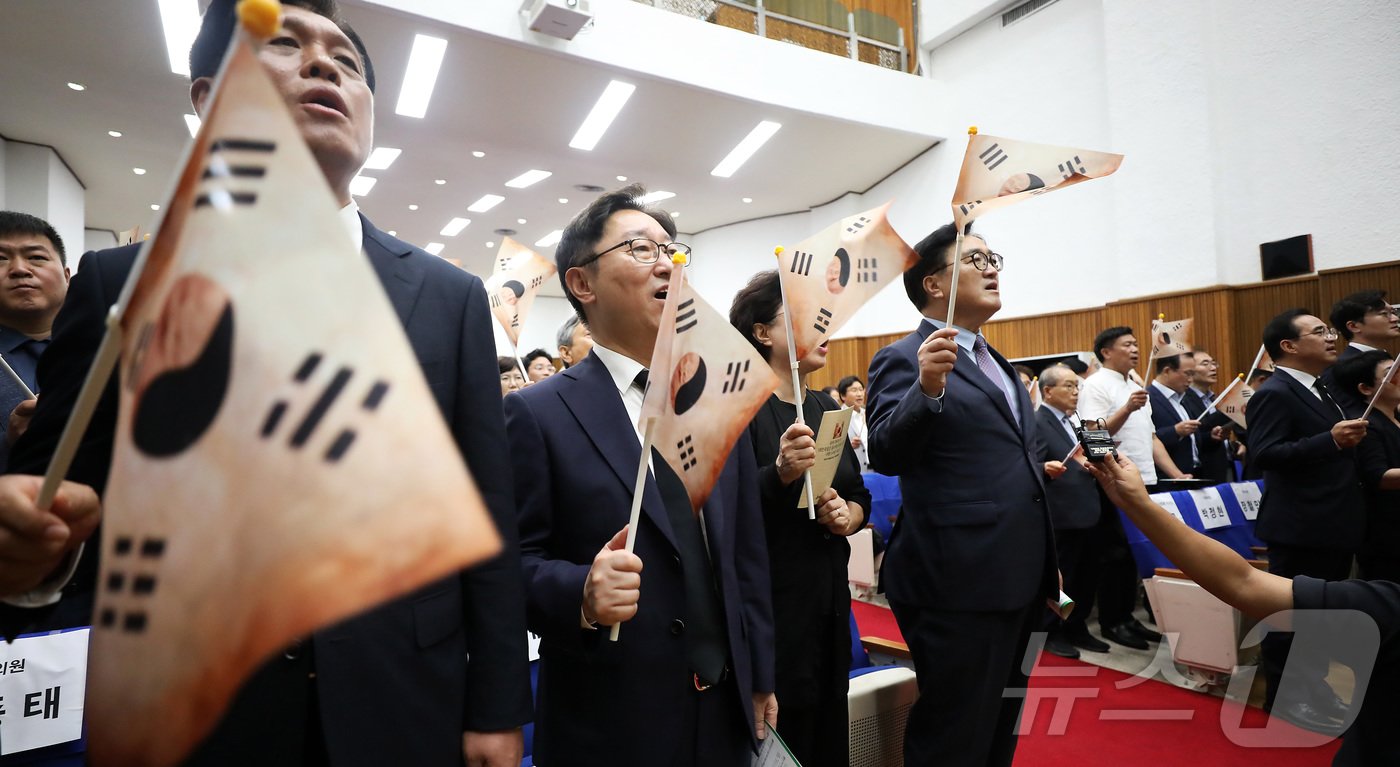 본문 이미지 - 우원식 국회의장이 14일 오전 대전국립현충원에서 열린 광복 79주년 및 홍범도 장군 귀환 3주년 기념식에 참석하여 참석자들과 함께 봉오동 전투에서 사용했던 태극기를 흔들며 광복절 노래를 제창하고 있다.2024.8.14/뉴스1 ⓒ News1 김기남 기자