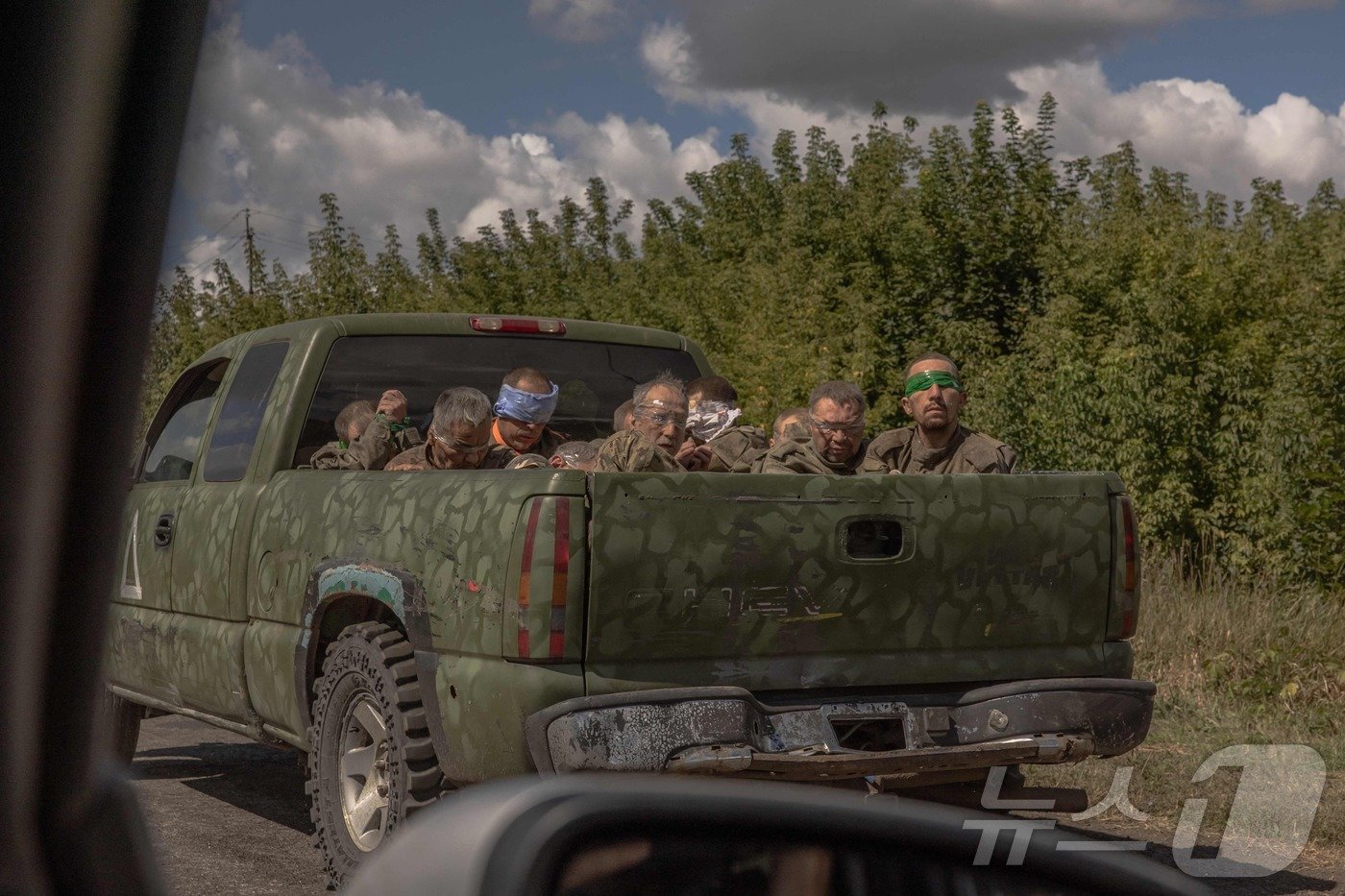 본문 이미지 - 13일(현지시간) 우크라이나 수미 지역에서 우크라이나 군용 차량이 눈을 가린 러시아 군복 차림의 남성들을 태우고 어디론가 이동하고 있다. 우크라이나는 지난 6일 국경을 넘어 러시아 서남부의 쿠르스크주를 공격해 최대 30km까지 돌파했다. 러시아가 외국의 공격에 자국 영토를 빼앗긴 것은 제2차 세계대전 이후 처음이다. 우크라이나군의 올렉산드르 시르스키 총사령관은 12일 러시아 영토 1000㎢를 점령했다고 주장하기도 했다. 2024.08.13 ⓒ AFP=뉴스1 ⓒ News1 김지완 기자