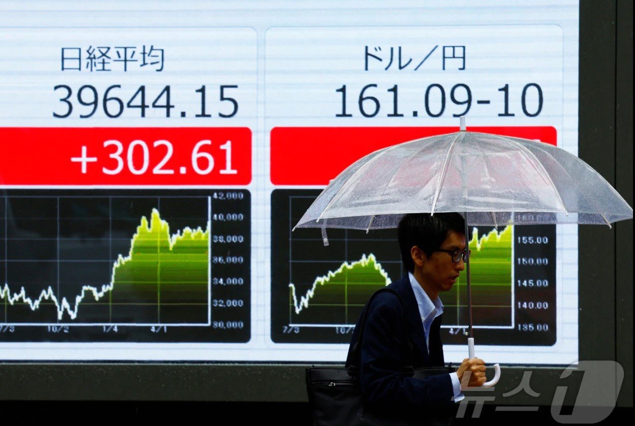 본문 이미지 - 일본 도쿄 거리에 있는 엔달러 환율 전광판 앞으로 한 시민이 지나가고 있다. 이날 엔화는 달러 당 161을 넘어 최저치를 기록했다. 2024.06.28 ⓒ 로이터=뉴스1 ⓒ News1 임여익 기자