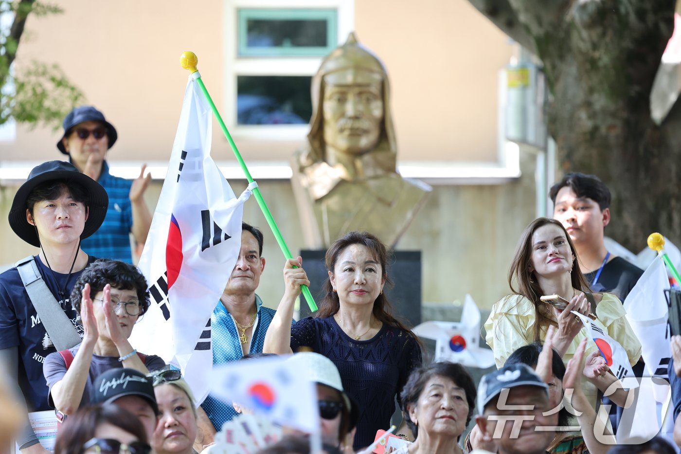 제79주년 광복절을 맞아 15일 광주광역시 광산구 월곡동 고려인마을에서 열린 기념행사를 지켜보는 참석자들 뒤로 홍범도 장군 흉상이 보이고 있다. 2024.8.15/뉴스1 ⓒ News1 김태성 기자