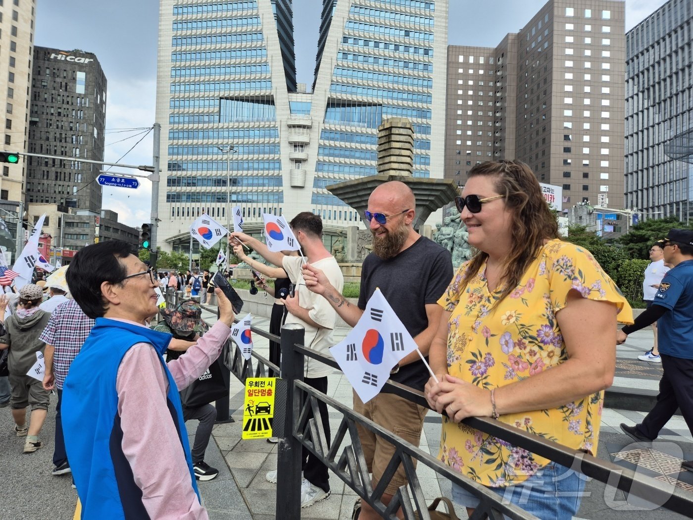 본문 이미지 - 광복절인 15일 오후 자유우파총연합의 거리 행진을 지켜보는 외국인 관광객들 모습 2024.8.15/뉴스1 ⓒ News1 조유리 기자
