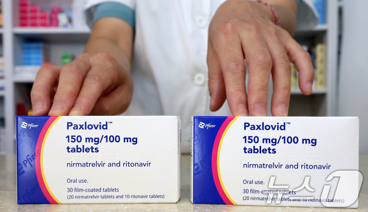 본문 이미지 - 코로나19 확산세가 커지는 가운데 16일 서울시내 약국에서 약사가 코로나19 치료제 팍스로비드를 들고 있다.  2024.8.16/뉴스1 ⓒ News1 장수영 기자