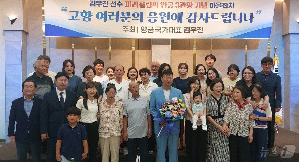 본문 이미지 - 2024 파리올림픽에서 양궁 3관왕을 달성한 김우진이 17일 충북 옥천군 옥천읍 한 음식점에서 열린 환영 행사에서 가족들과 기념사진을 찍고 있다. /뉴스1 