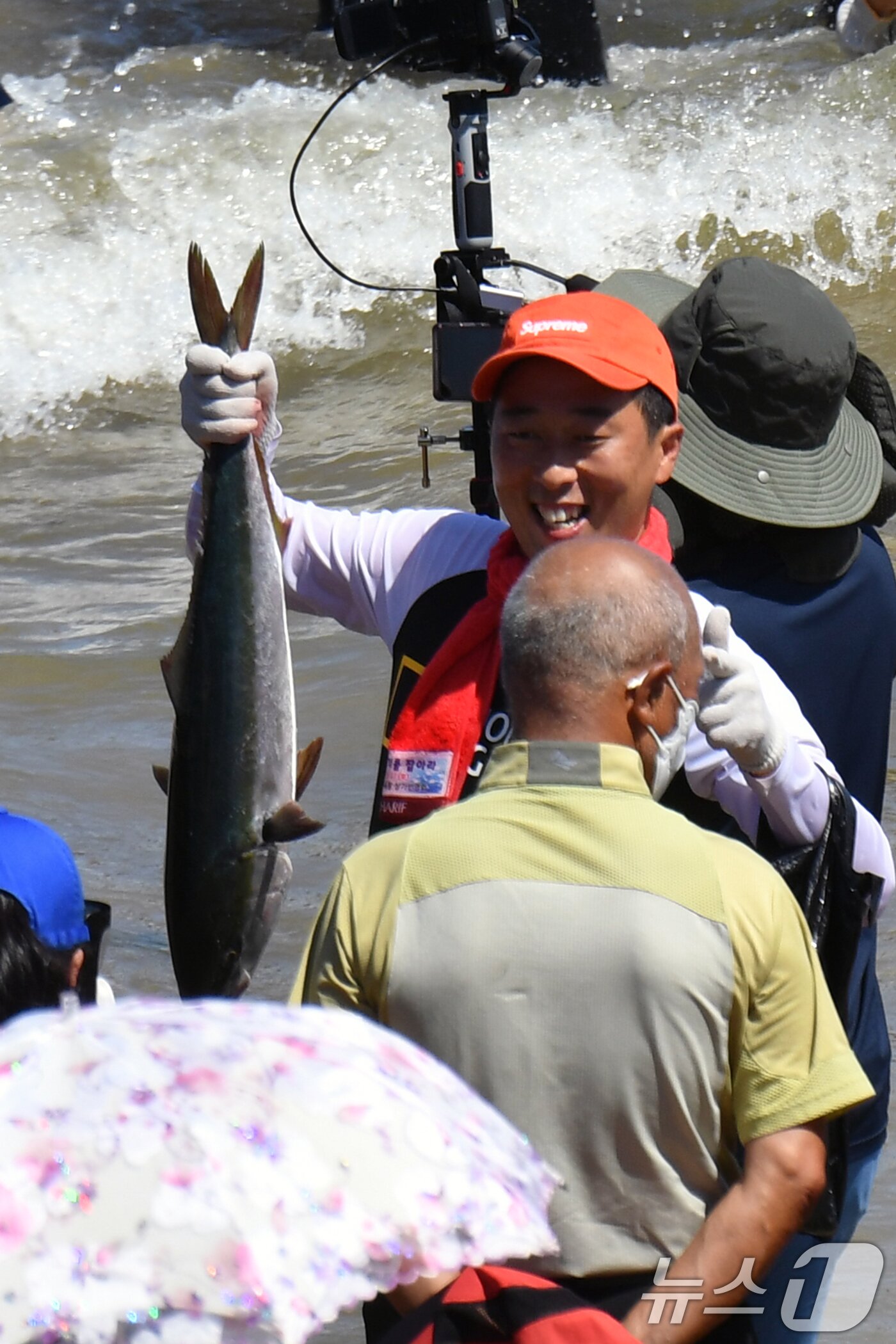 본문 이미지 - 17일 경북 포항시 북구 영일대해수욕장에서 열린 '황금물고기를 잡아라'에 참여한 한 시민이 물고기를 들어보고 있다. 2024.8.17/뉴스1 ⓒ News1 최창호 기자