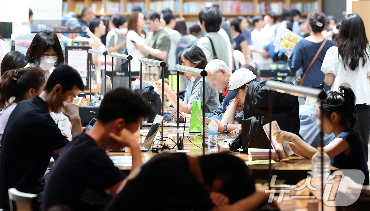 (서울=뉴스1) 김진환 기자 = 전국 대부분 지역에 폭염특보가 발효된 18일 오후 서울 강남구 스타필드 코엑스몰 별마당 도서관에서 시민들이 독서를 하고 있다. 2024.8.18/뉴 …