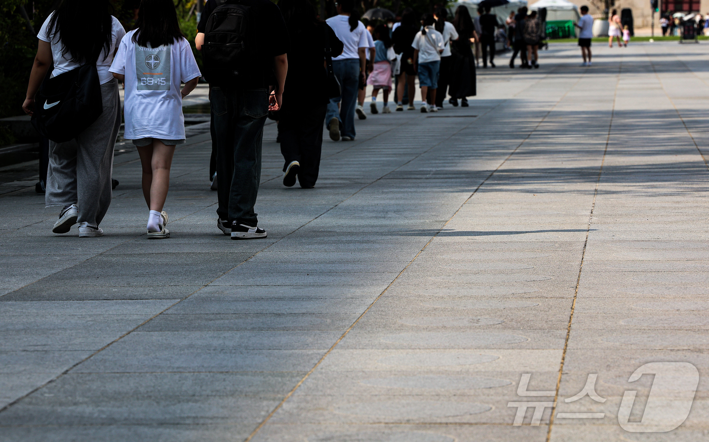 (서울=뉴스1) 김도우 기자 = 무더위가 이어진 18일 서울 종로구 광화문광장에서 시민들이 그늘을 이용해 이동하고 있다. 2024.8.18/뉴스1