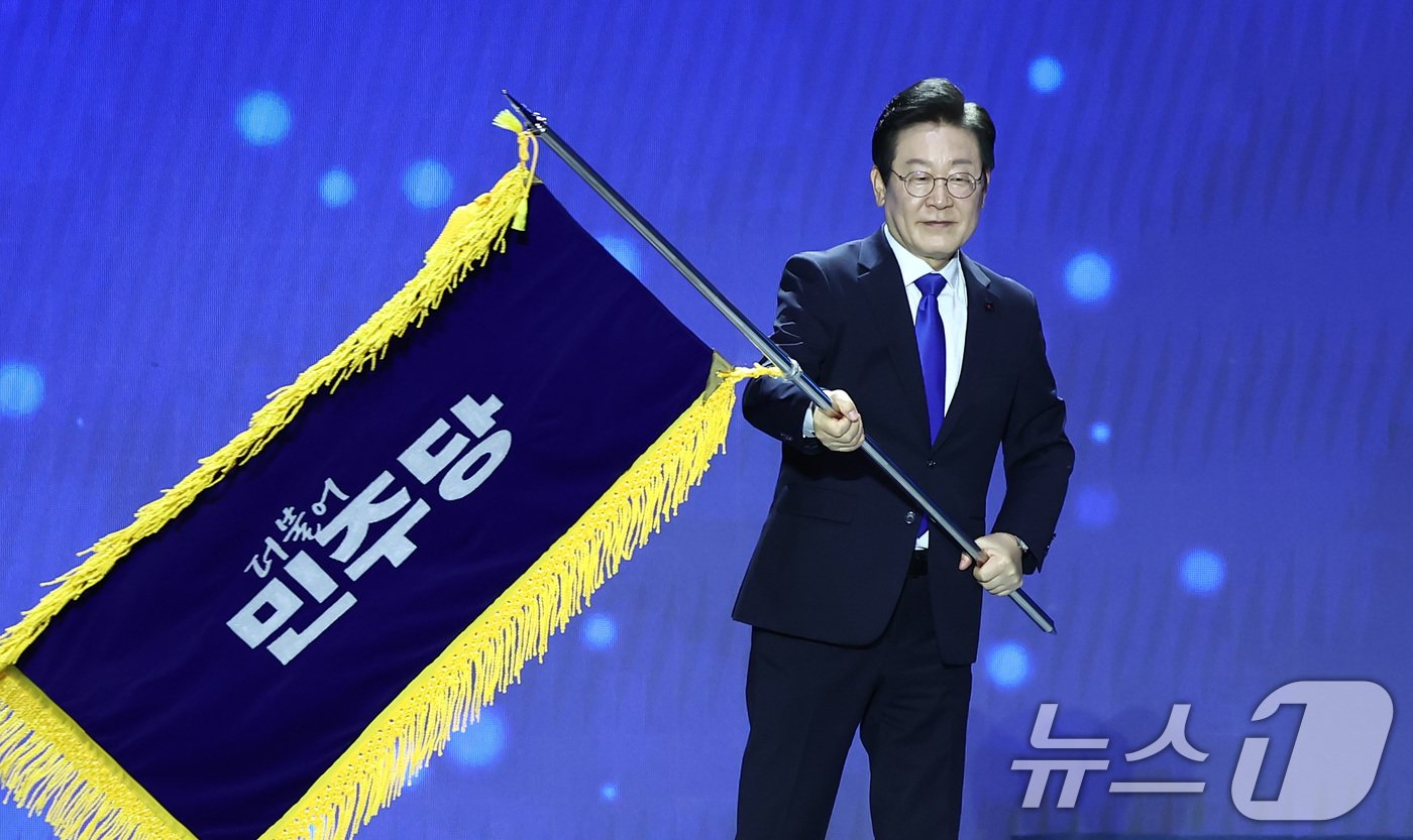 본문 이미지 - 이재명 더불어민주당 대표가 18일 오후 서울 송파구 KSPO DOME&#40;올림픽체조경기장&#41;에서 열린 제1차 정기전국당원대회에서 당기를 흔들고 있다. 2024.8.18/뉴스1 ⓒ News1 김민지 기자