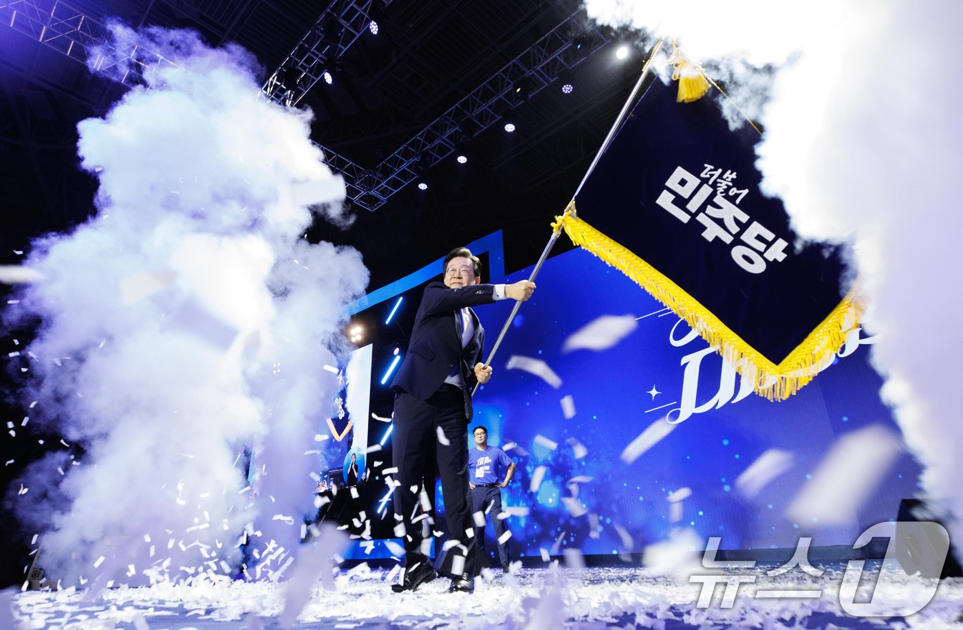 본문 이미지 - 연임에 성공한 이재명 더불어민주당 대표가 18일 오후 서울 송파구 올림픽공원 KSPO돔에서 열린 제1차 정기전국당원대회에서 당기를 흔들고 있다. (공동취재)2024.8.18/뉴스1 ⓒ News1 김민지 기자