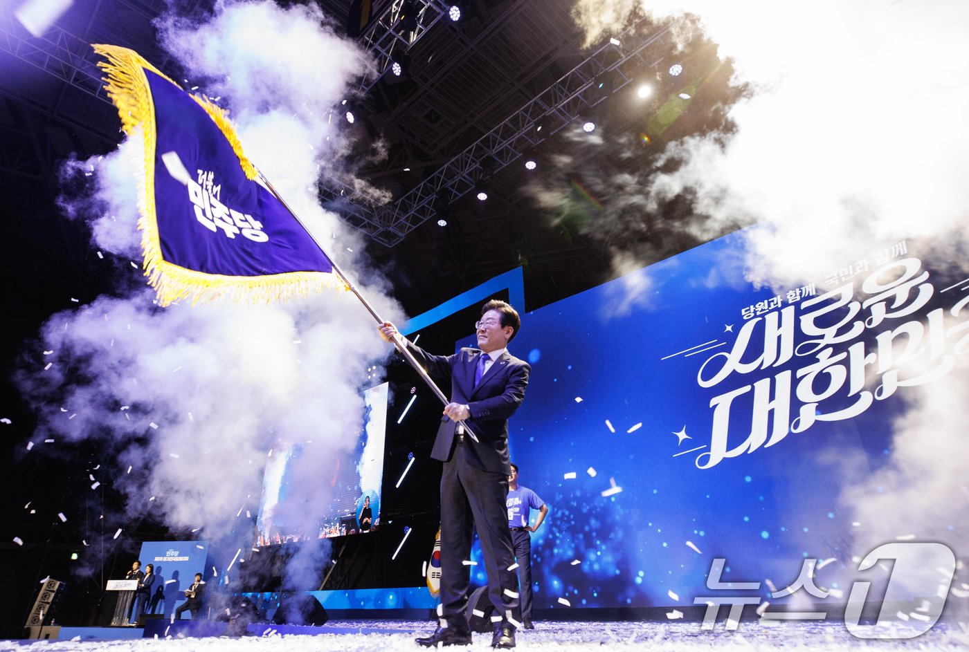 본문 이미지 - 연임에 성공한 이재명 더불어민주당 대표가 18일 오후 서울 송파구 올림픽공원 KSPO돔에서 열린 제1차 정기전국당원대회에서 당기를 흔들고 있다. (공동취재)2024.8.18/뉴스1 ⓒ News1 김민지 기자