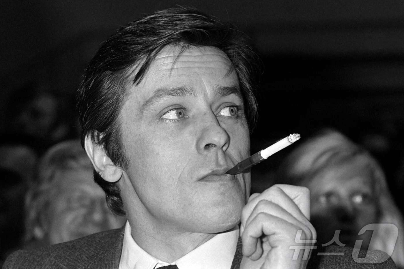 본문 이미지 - 젊은 시절 알랭 들롱의 사진. 1976년 5월에 찍은 사진으로, 담배를 피우고 있다. ⓒ AFP=뉴스1 ⓒ News1 박형기 기자